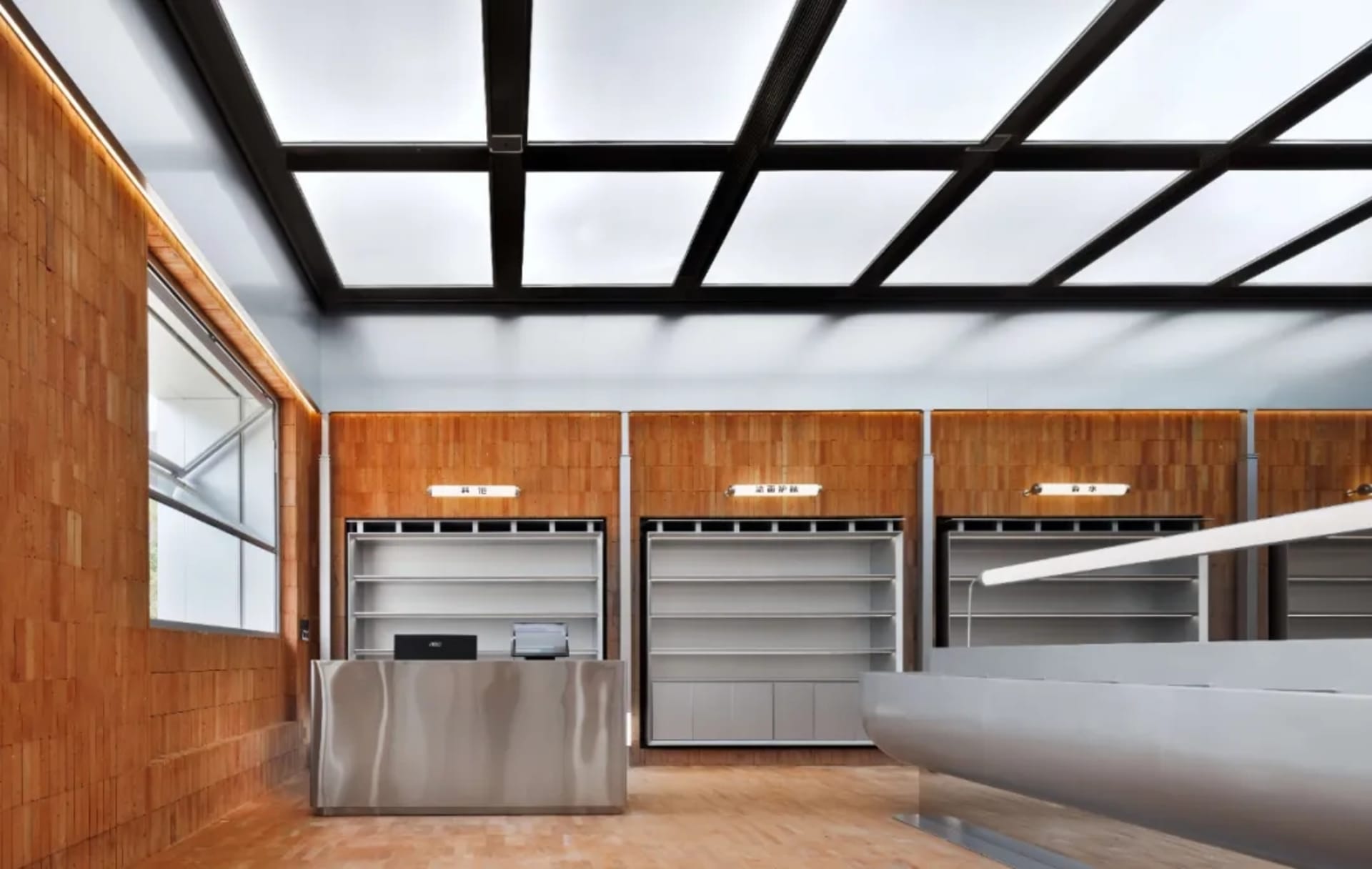 Modern industrial storefront featuring metallic counter, wooden shelves, and concrete floor.