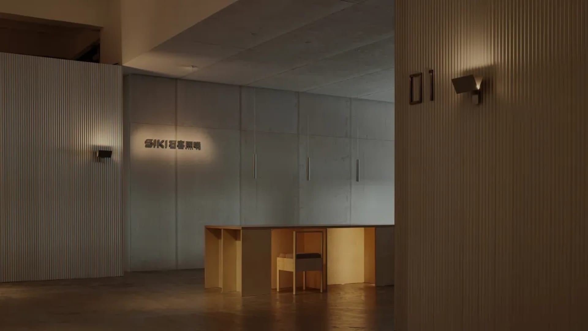 A minimalist lobby with concrete textures, featuring a desk and seating area.