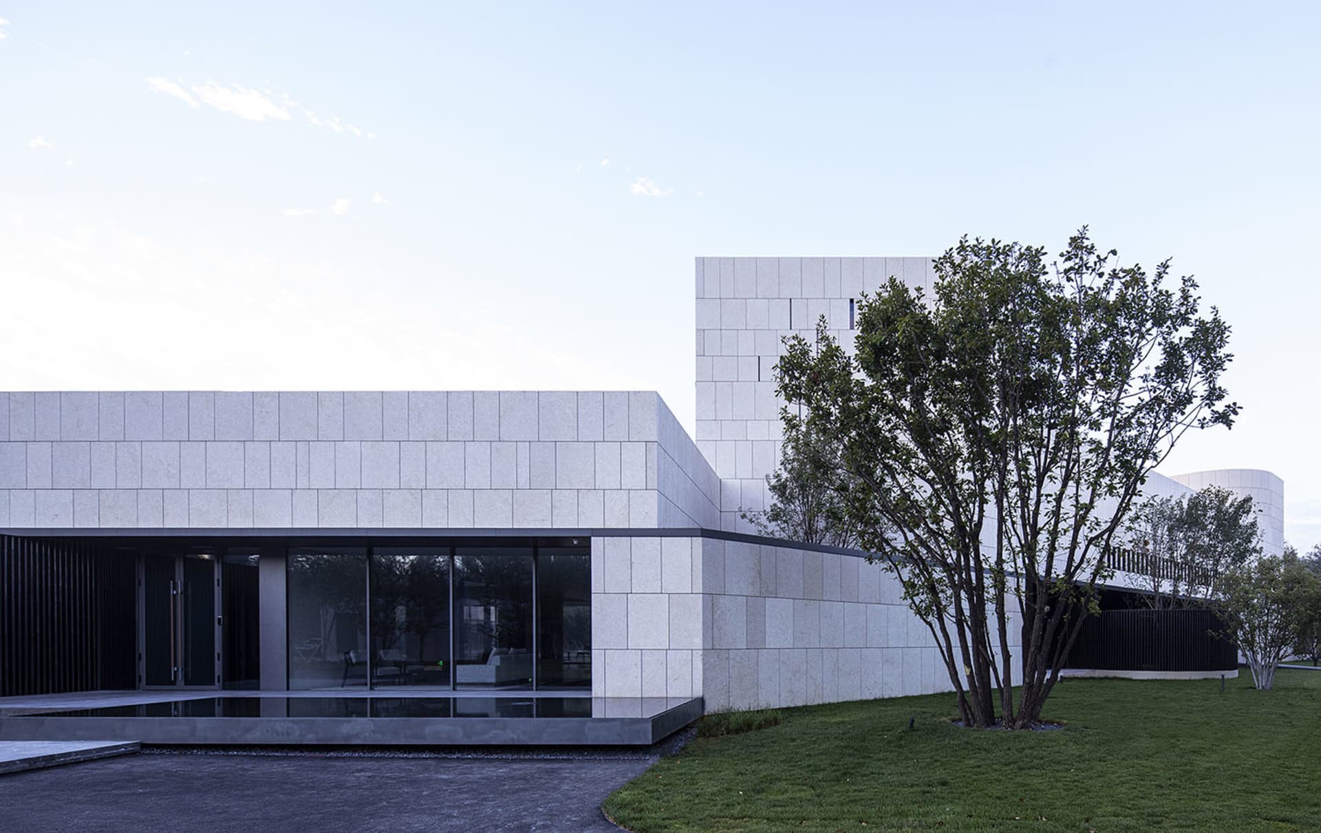 Modern architectural building with concrete exterior and large glass windows.