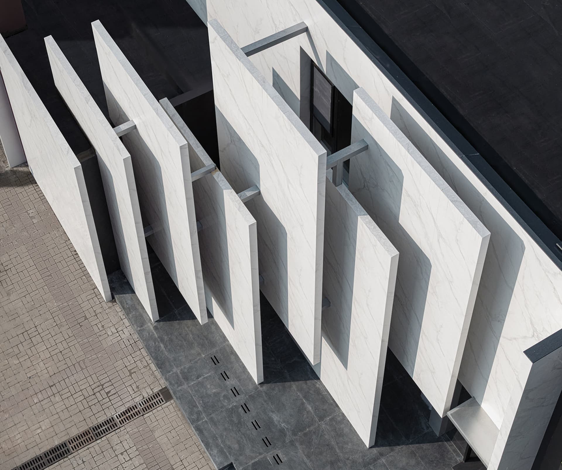 Modern architectural exterior featuring white marble panels and a minimalist design.