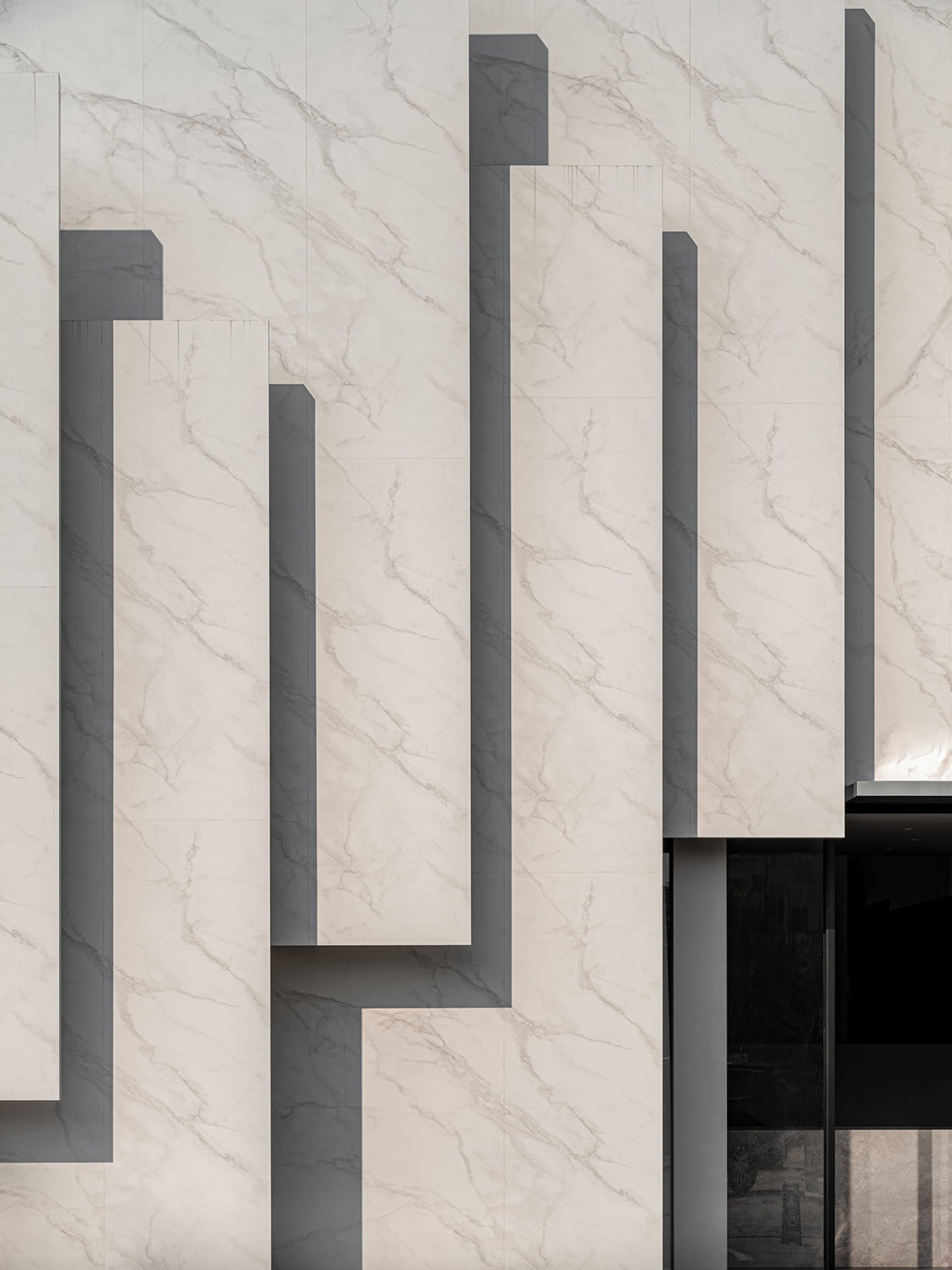 Modern exterior building facade with marble mosaic tiles.