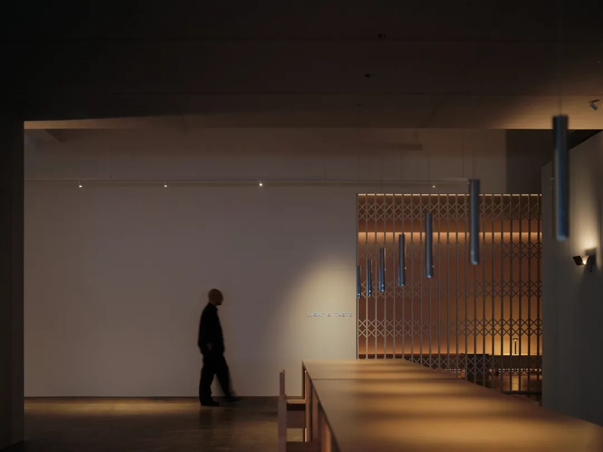 A minimalist restaurant interior with wooden tables, modern lighting fixtures, and a metal grille wall.