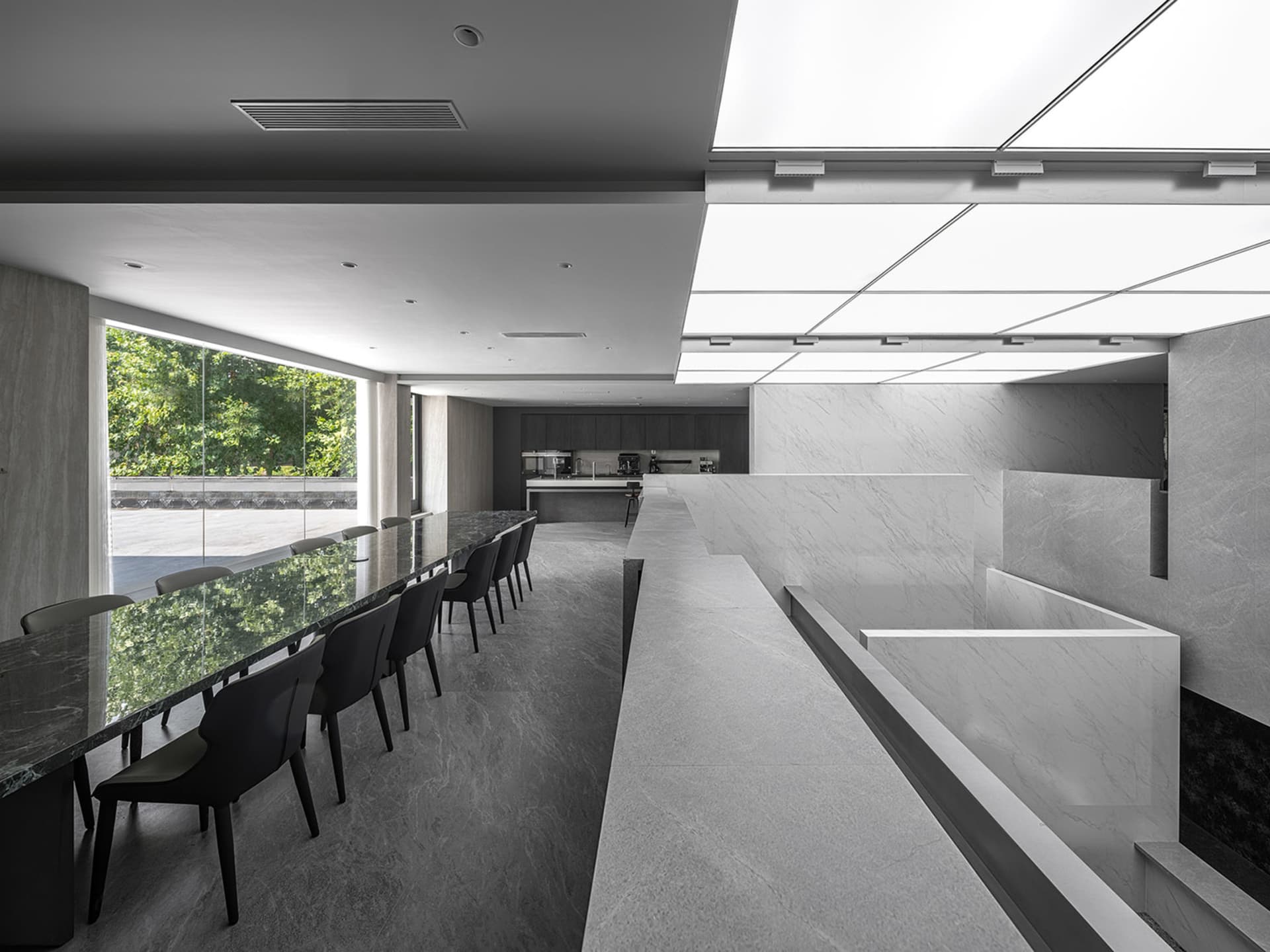 現代會議室內設有長桌與座椅,大理石地板與牆面,以及天花板燈具。