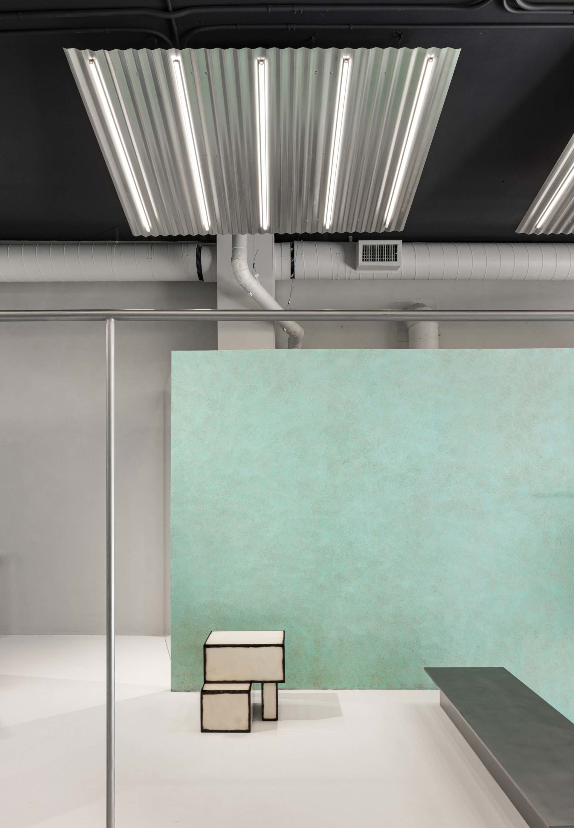 A minimalist interior with concrete walls and a bar area.