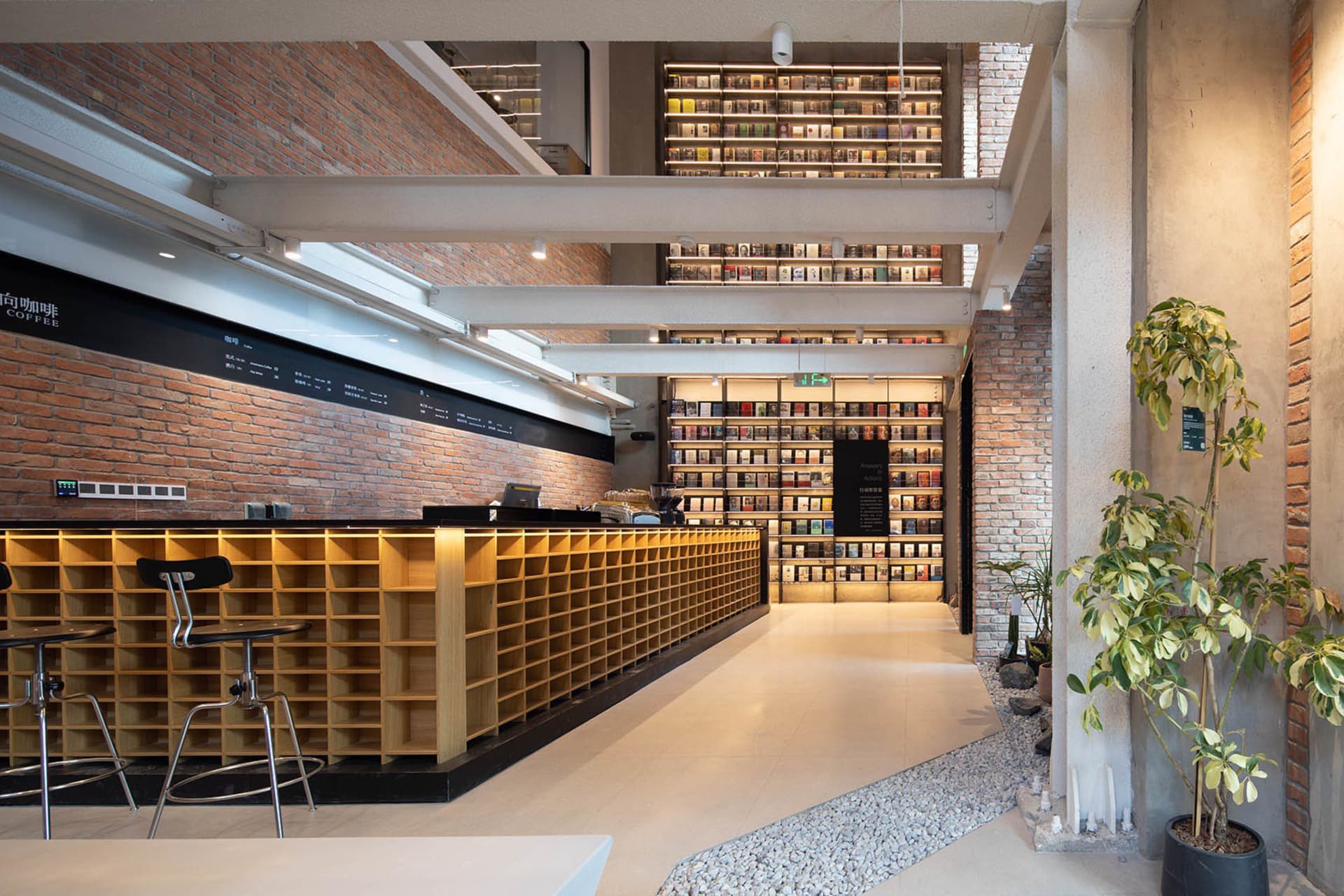 Industrial-themed coffee shop featuring exposed brick, concrete, and light wood elements.