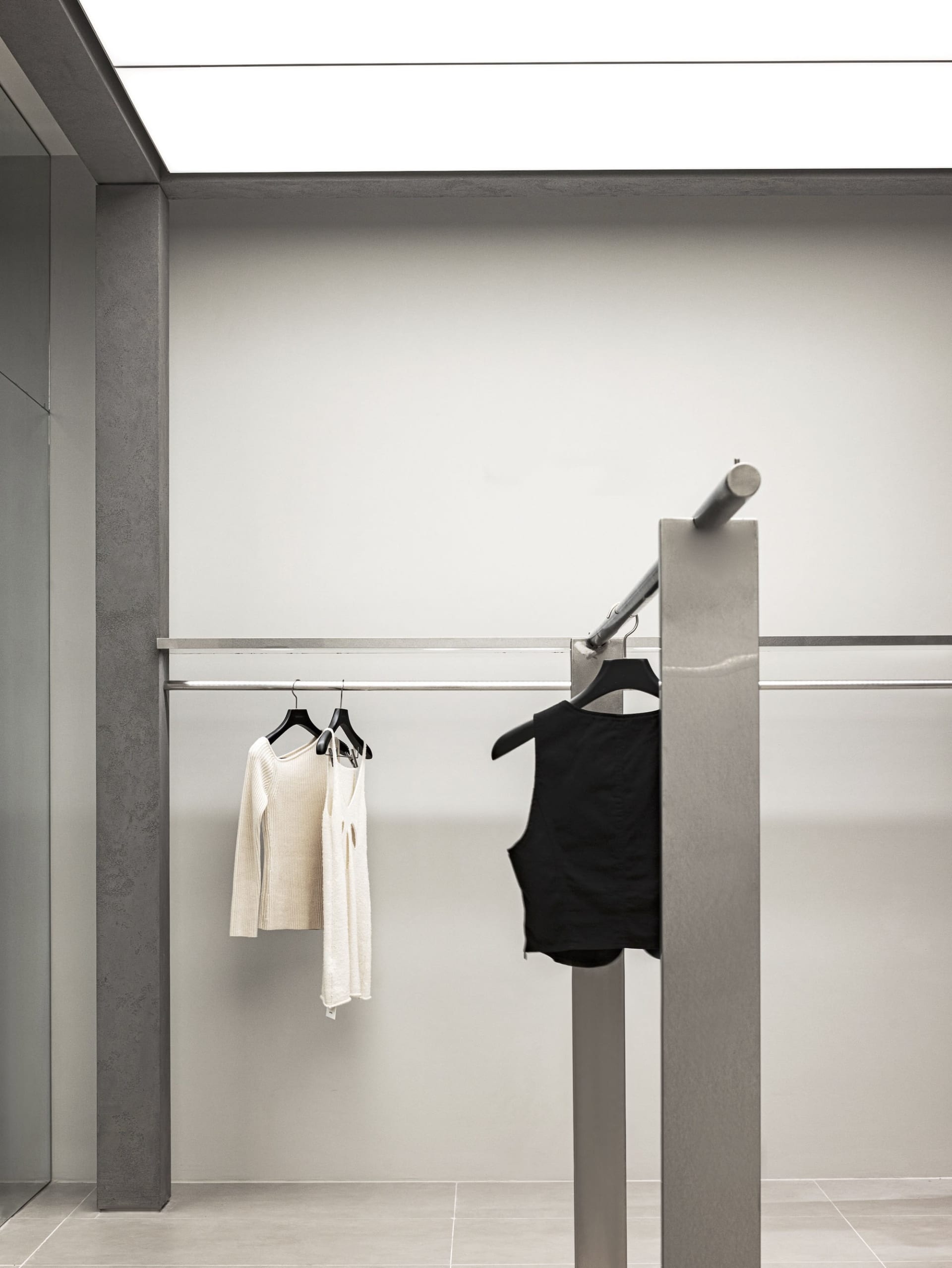 Modern clothing store interior featuring metal bars for clothing display.