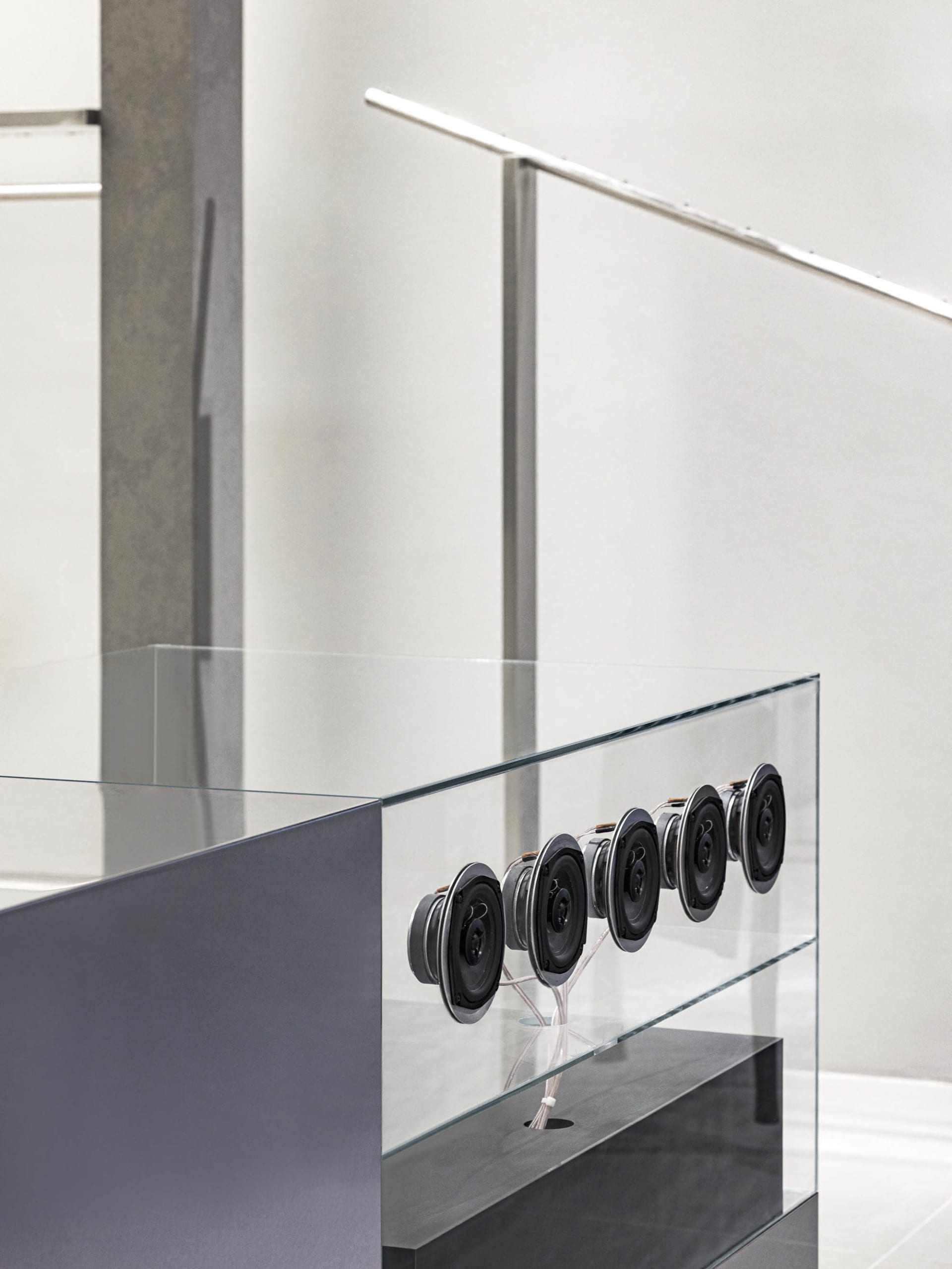 A modern interior space featuring a glass balustrade with a minimalist design.