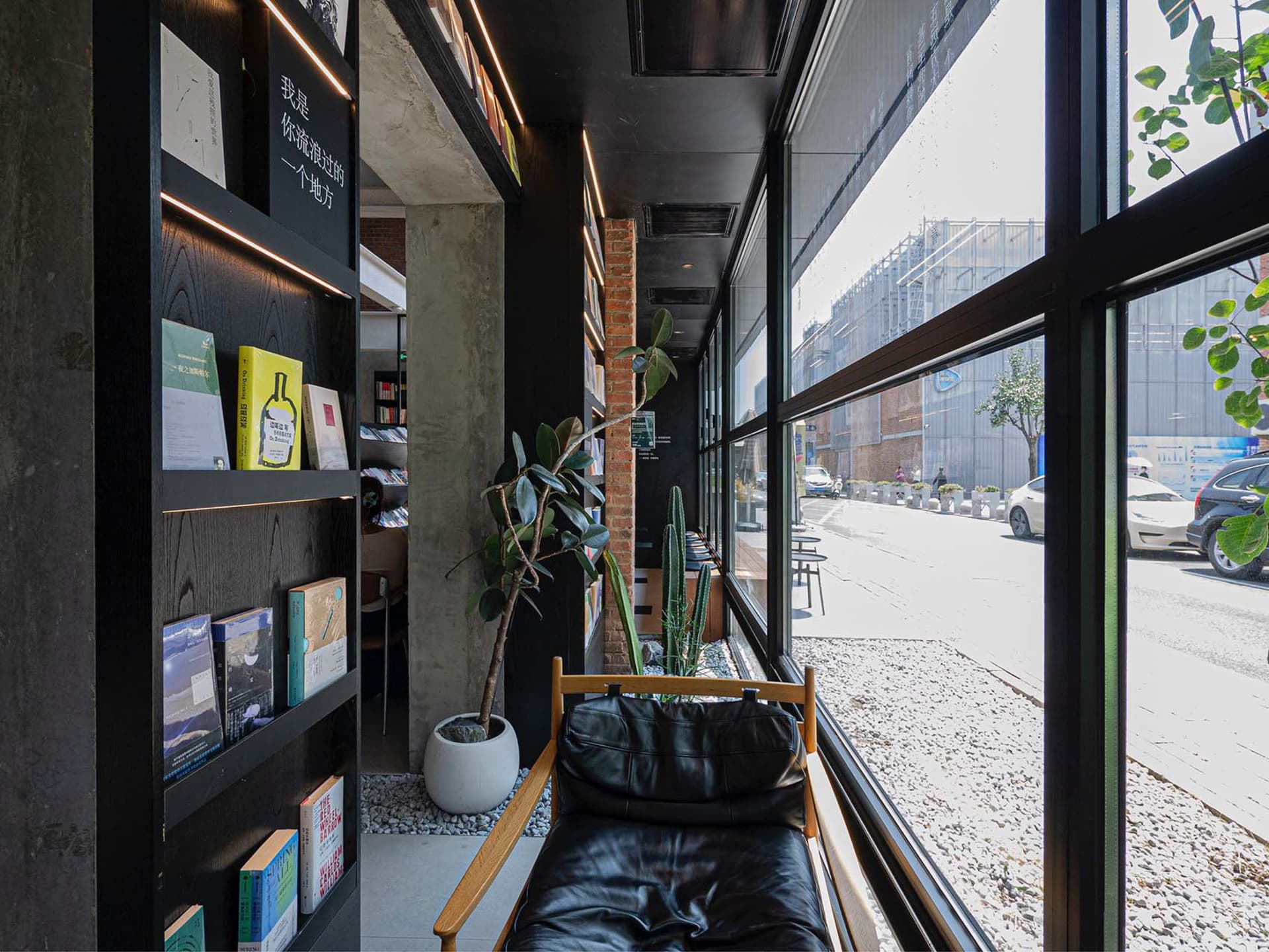 現代都市圖書館室內視圖，採用極簡設計，搭配黑色皮革家具、水泥牆面與大型