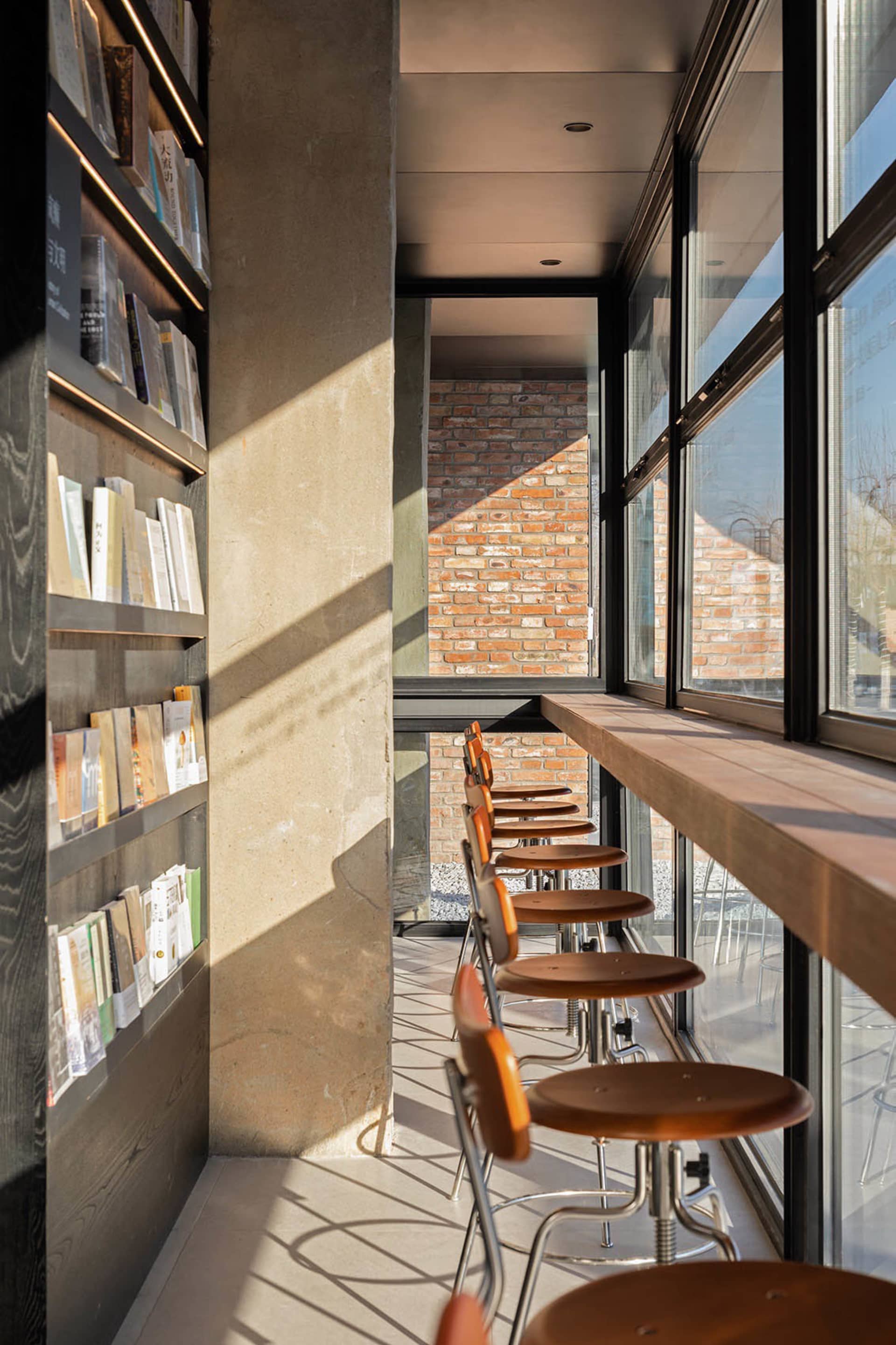 A modern coffee shop features a minimalist design with concrete, wood, and glass materials.