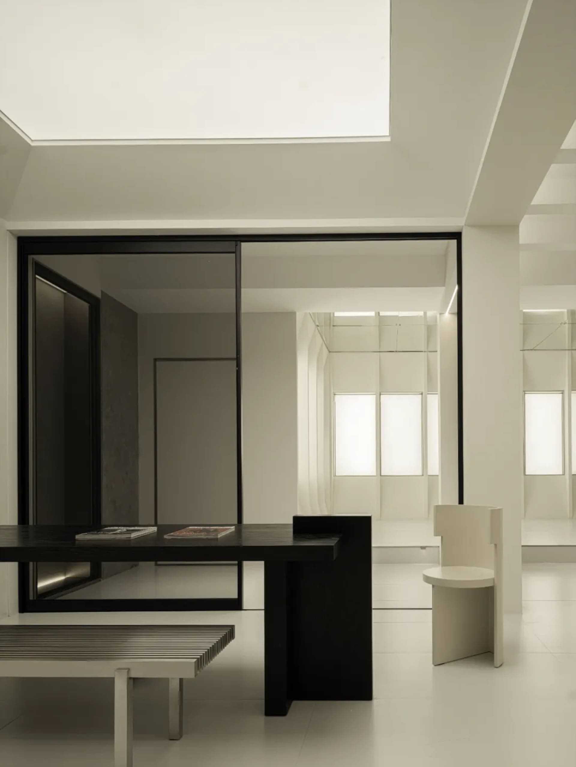 Modern minimalist office space featuring black and white furniture and decor.