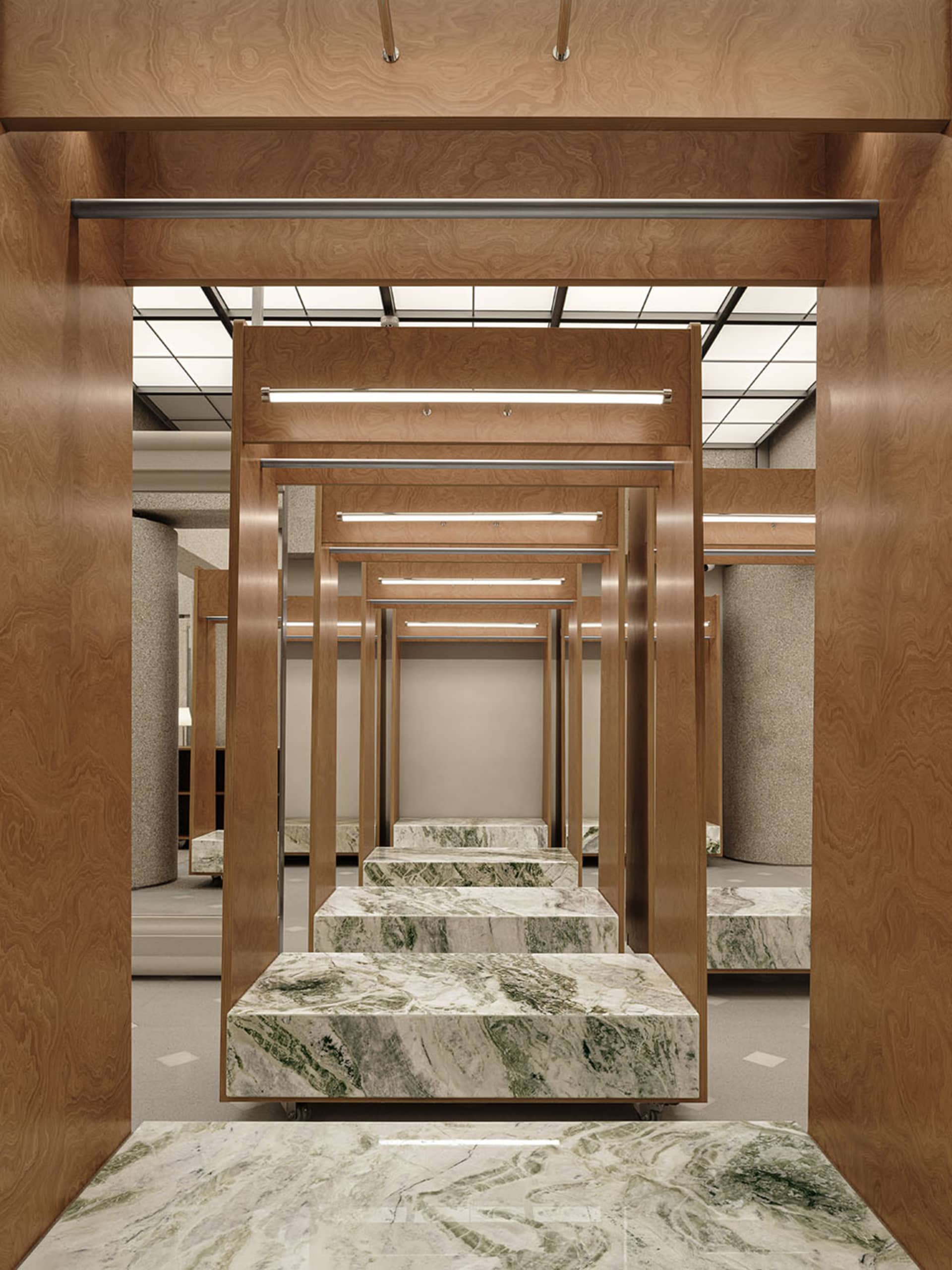 A retail dress fitting room with marble and wooden fixtures