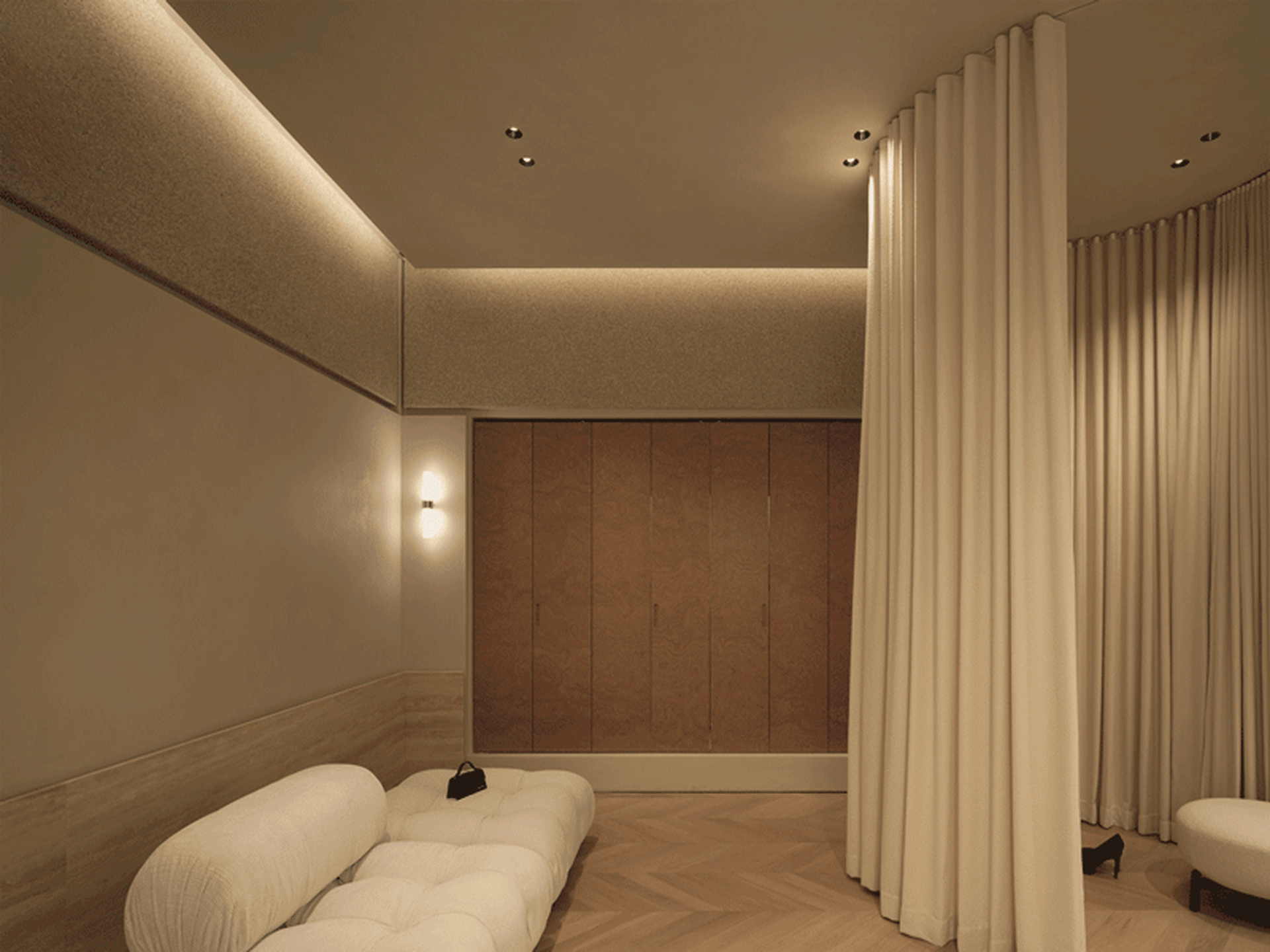 Luxuriously minimalist living space adorned with warm wood tones and elegant white textiles.