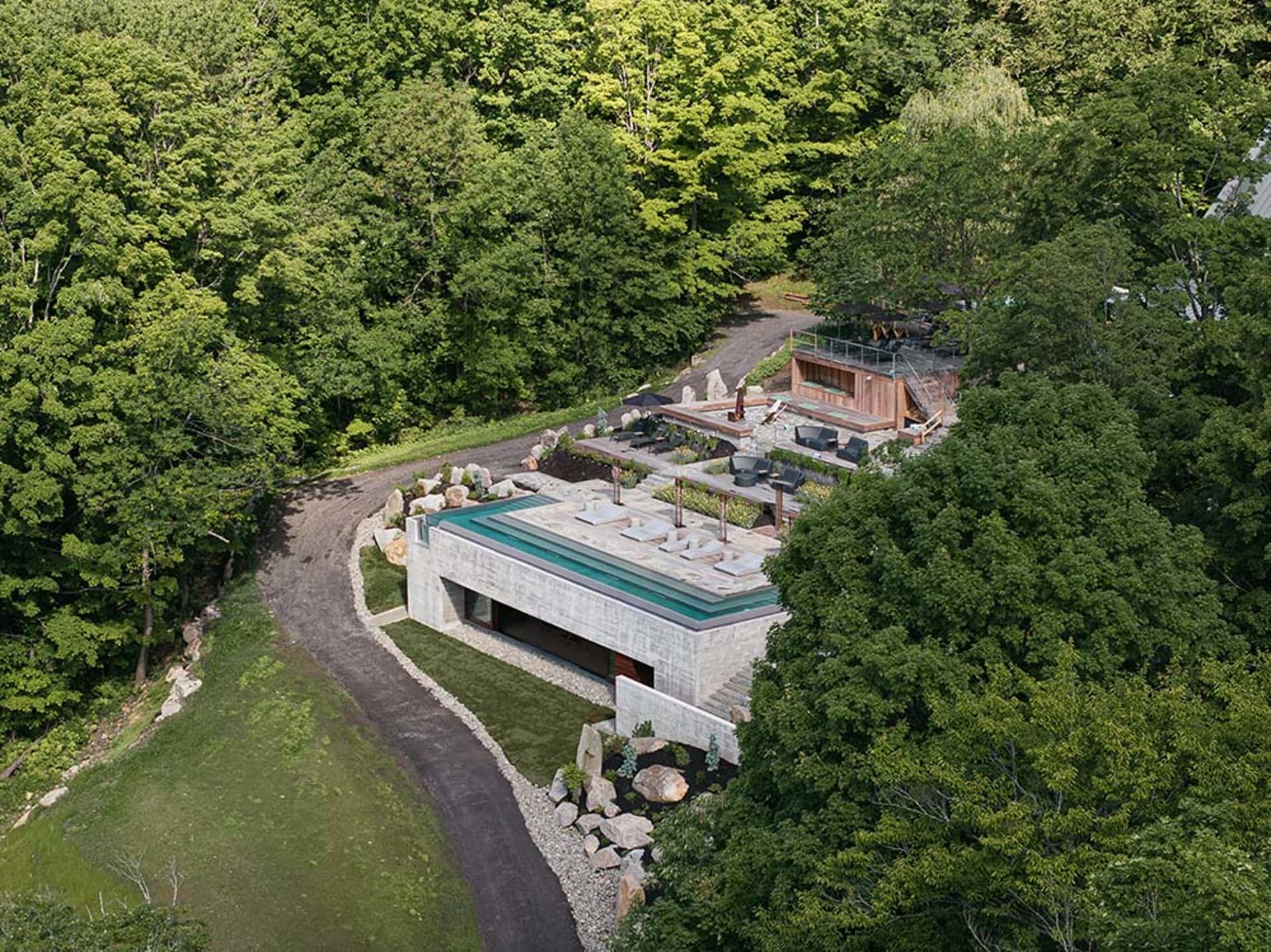 A modern residential exterior with concrete walls and a glass roof.