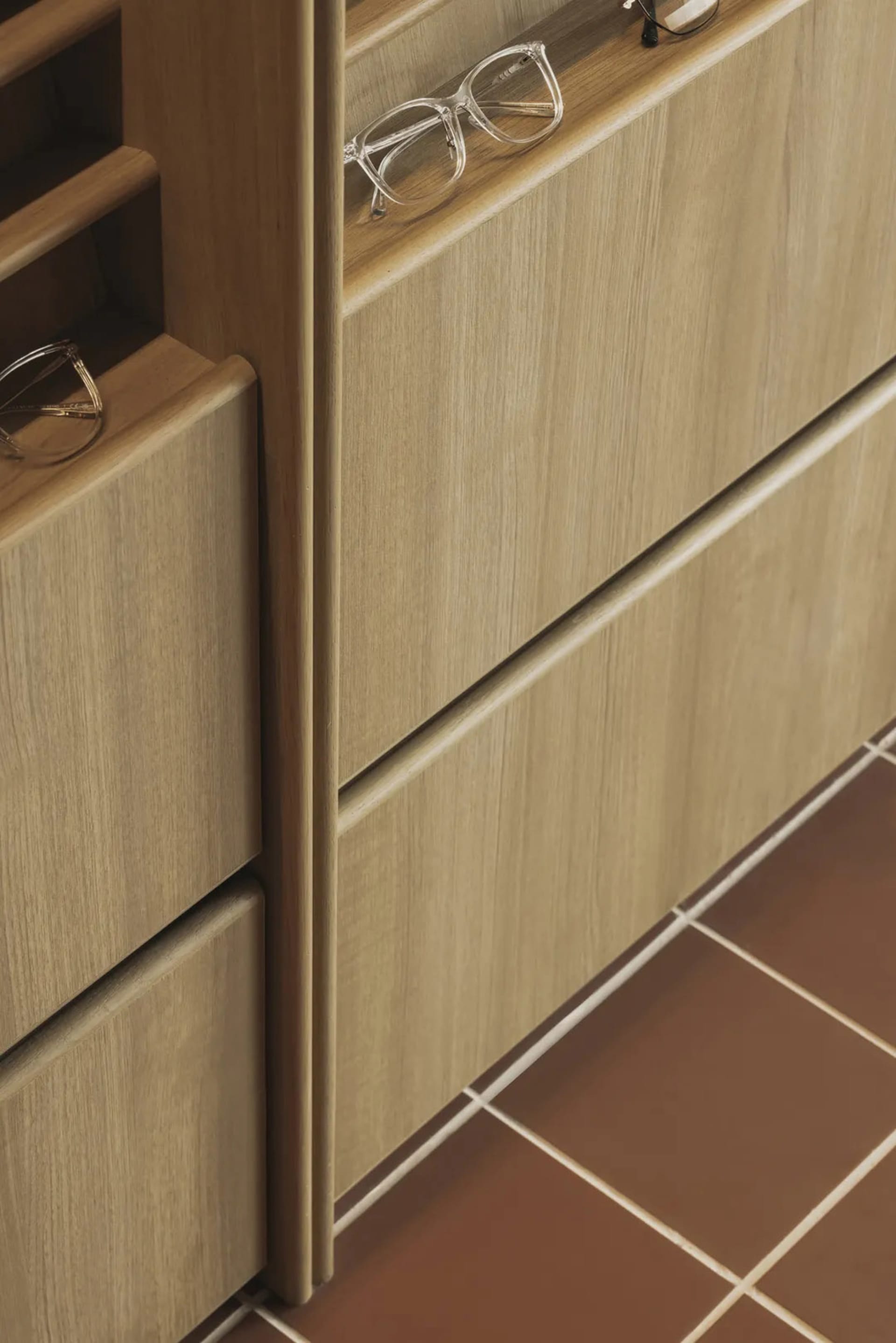 A modern shoe cabinet made of oak with two built-in drawers and a top shelf.