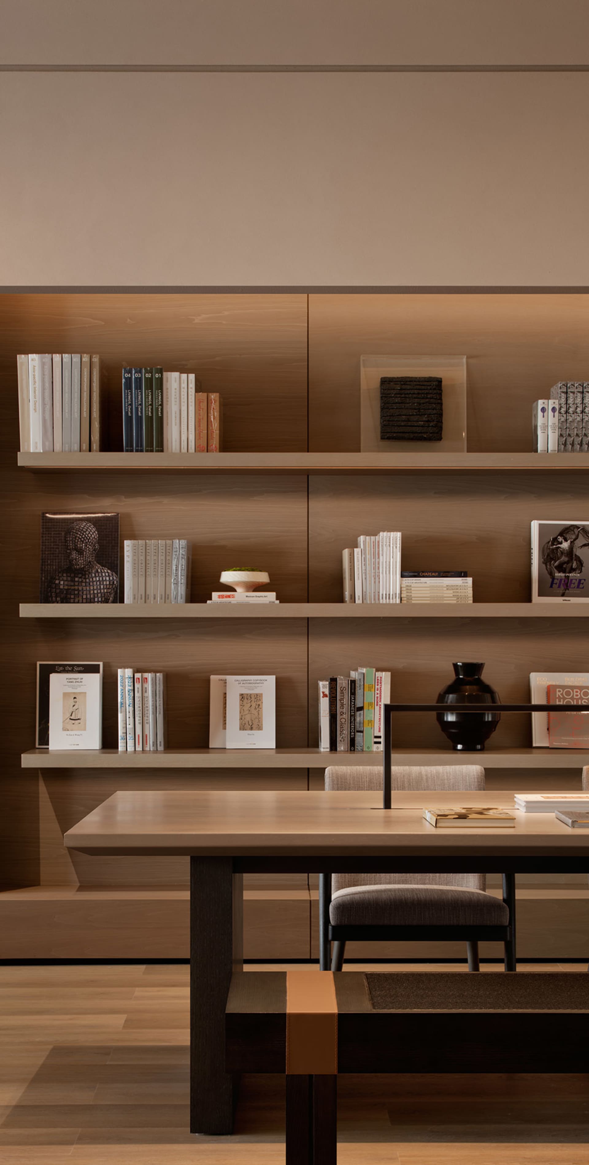 A modern home library with wooden shelves and stone accents.