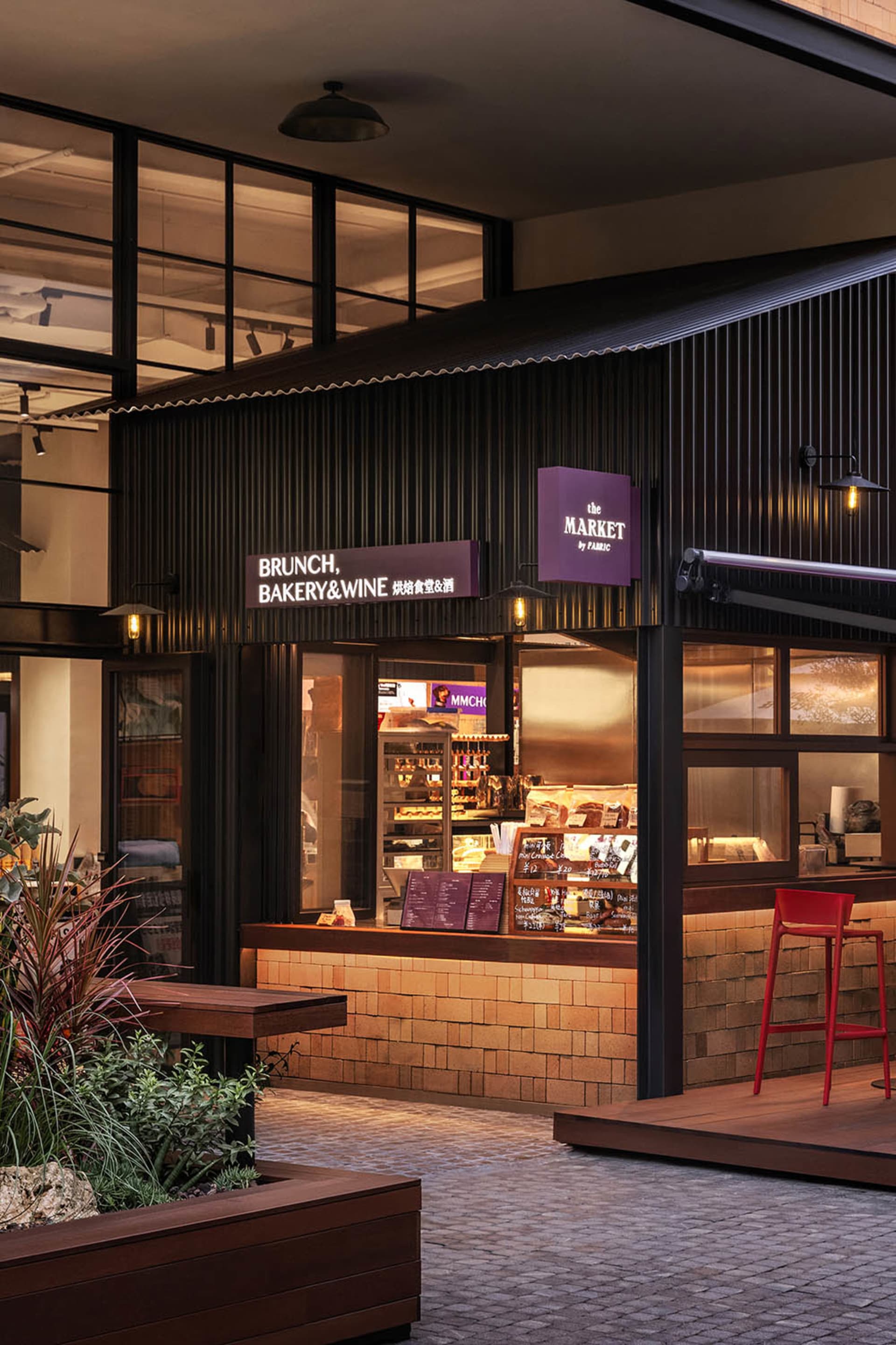 A modern industrial retail store featuring black metal, brick, and large windows.