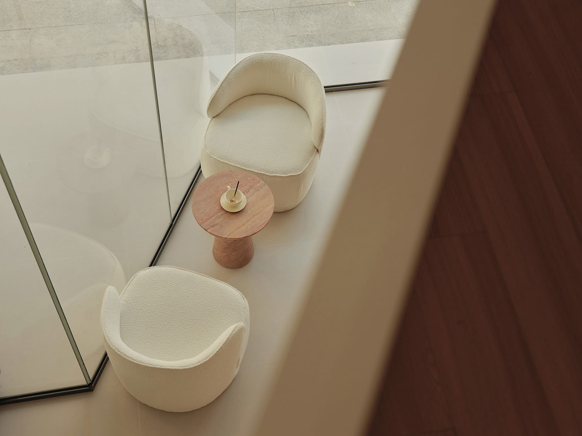 Modern minimalist living room with plush white fabric chairs and a round marble side table, ideal for elegant and comfortable