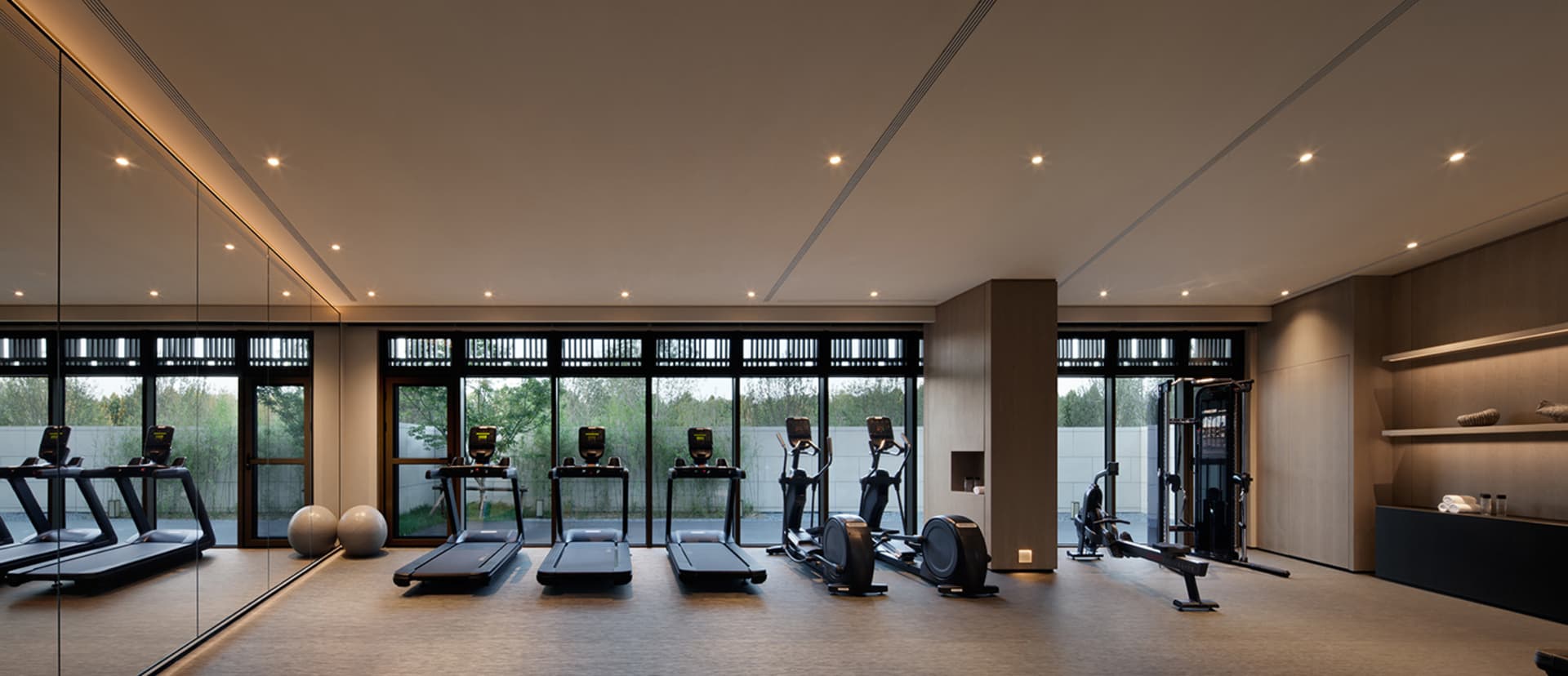 A modern fitness center equipped with treadmills, elliptical trainers, and stationary bikes.