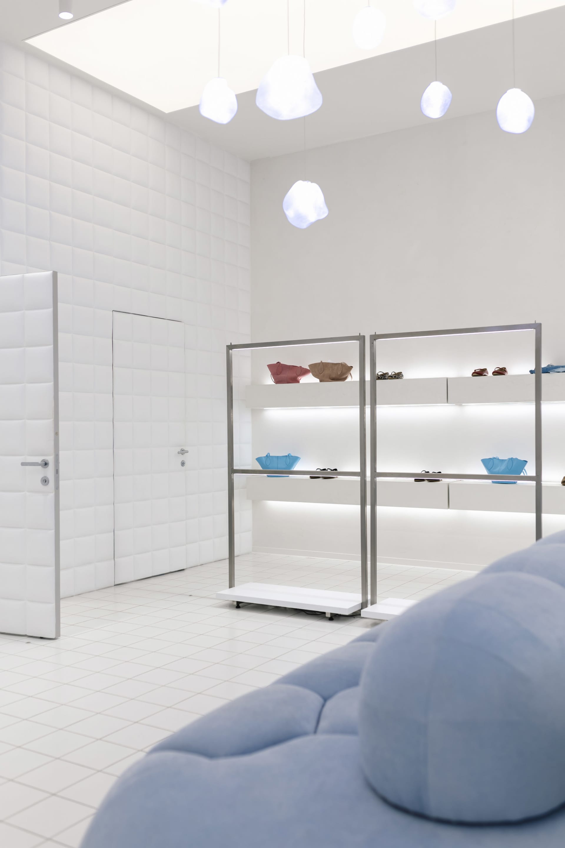 A minimalist retail space featuring metal, glass, and fabric elements.