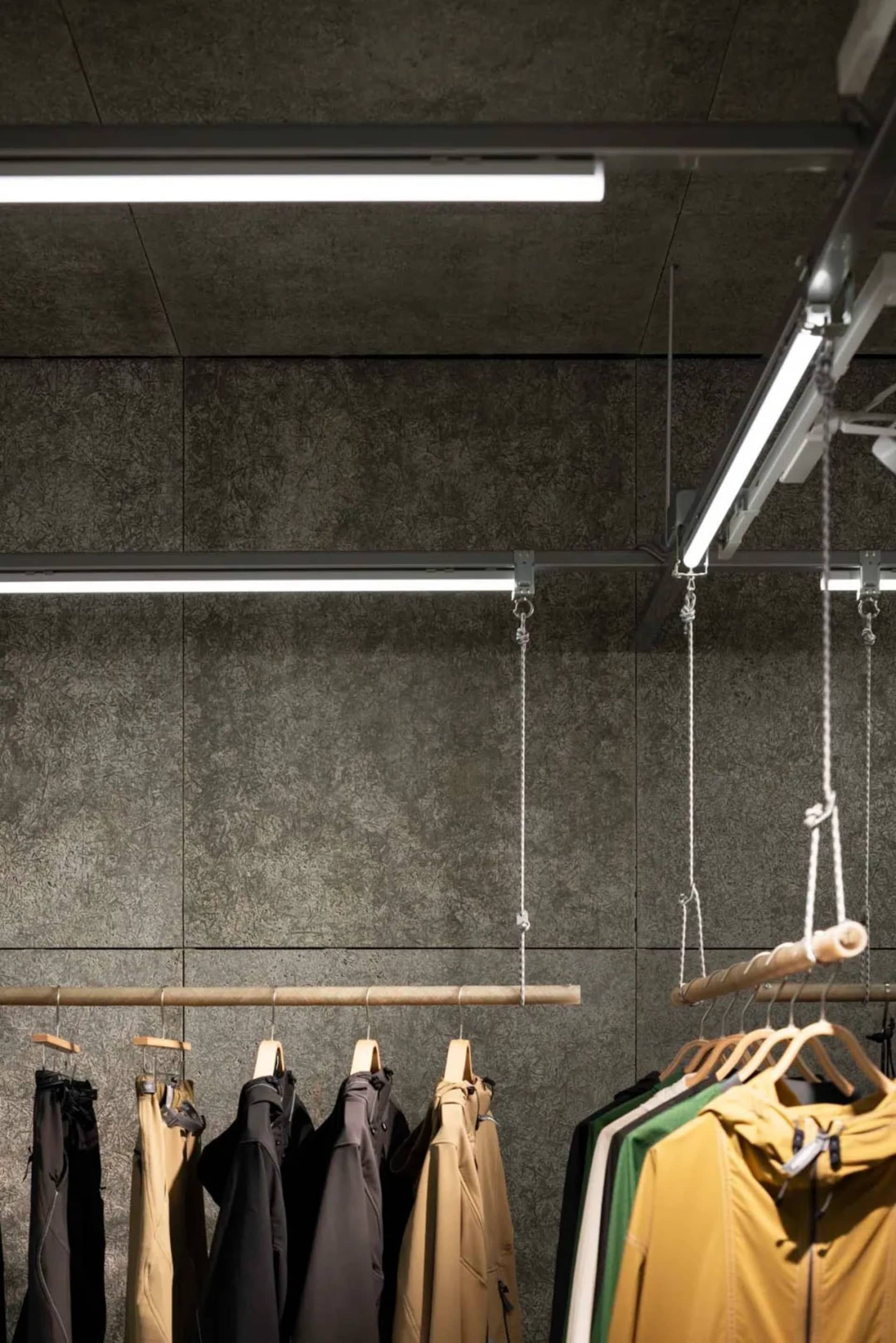 Modern retail store with clothing racks and lighting.