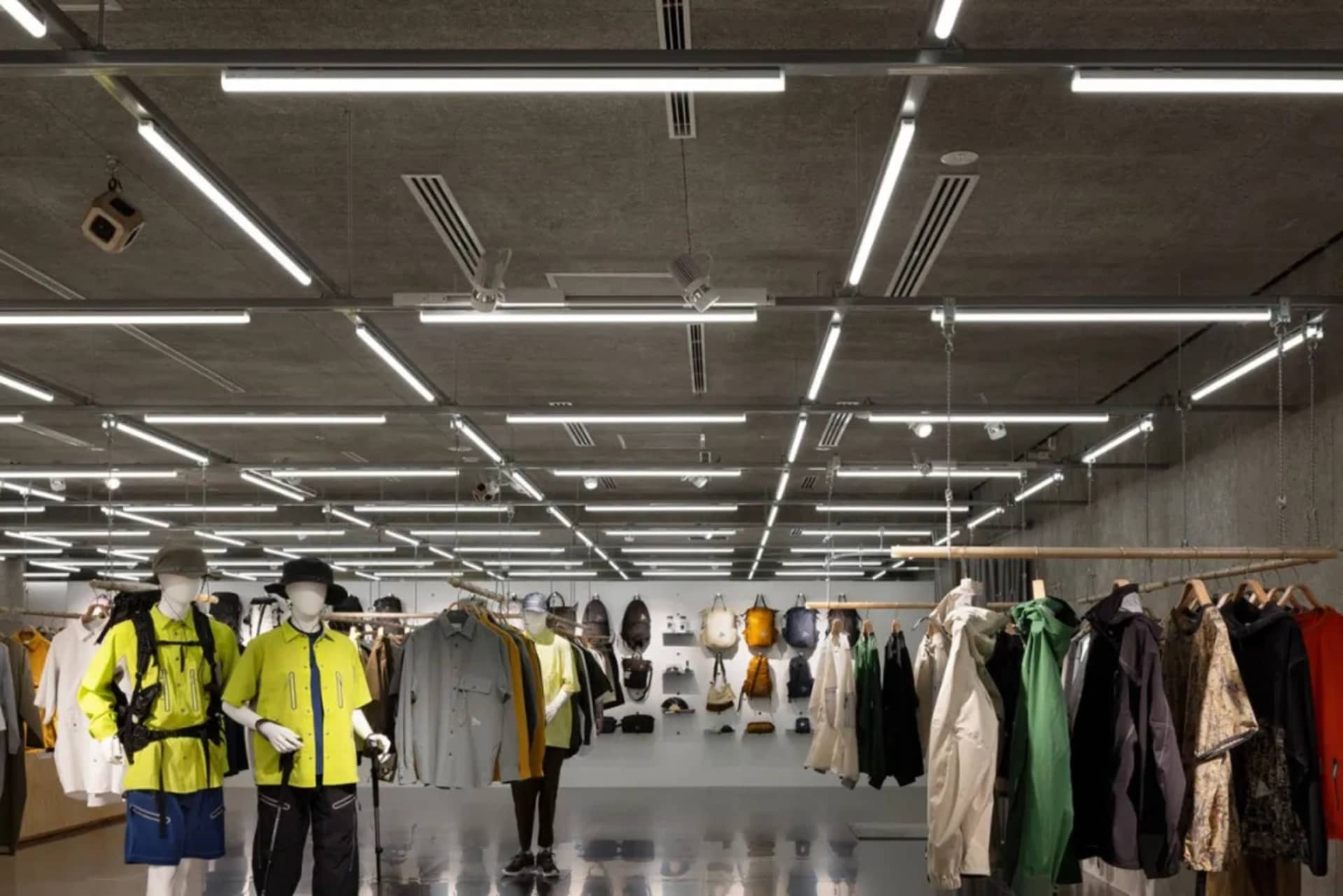 Industrial design retail shop featuring concrete kiosk with clothing items on display.