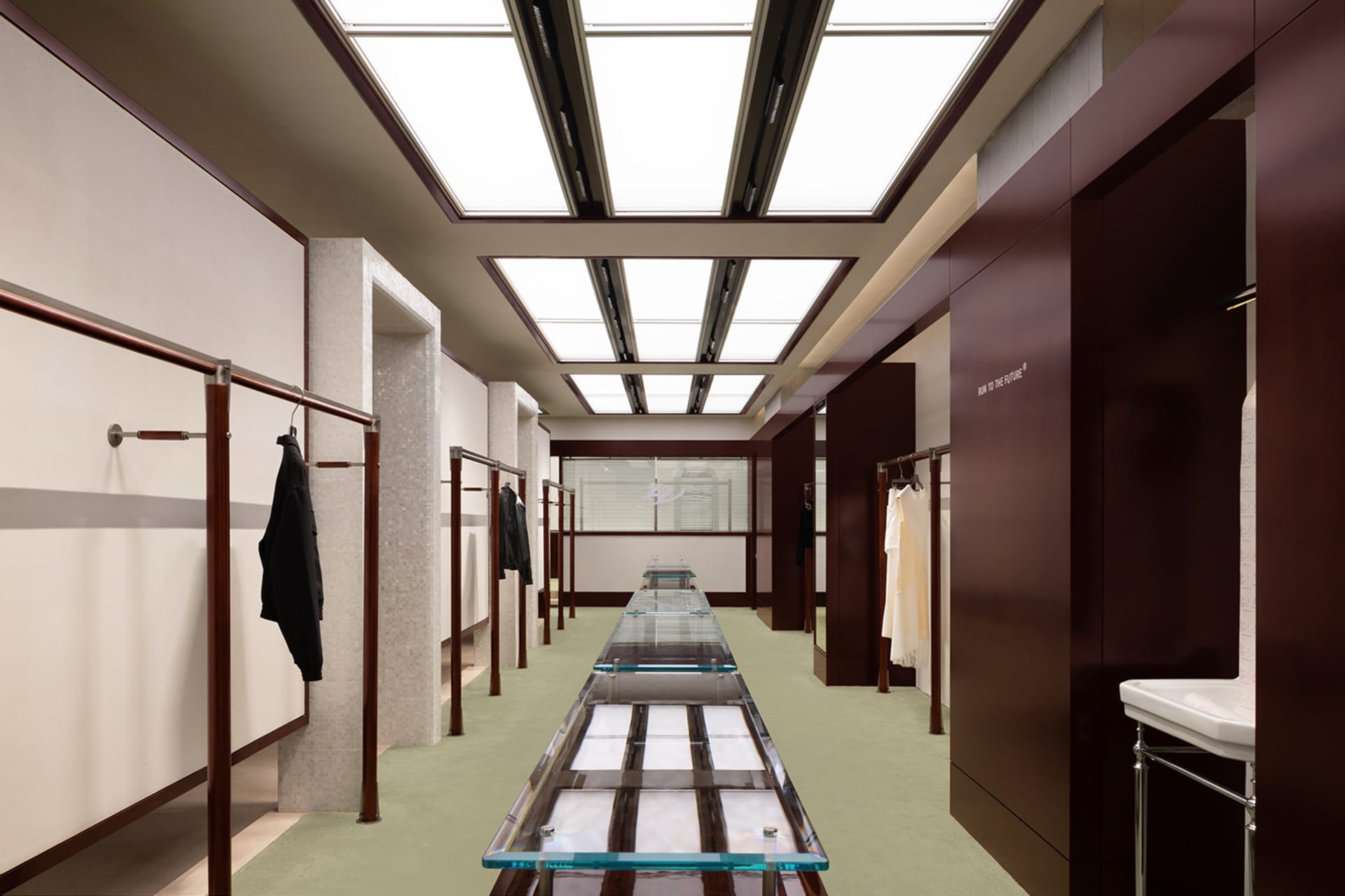 Modern, minimalist clothing rack made of steel and glass.