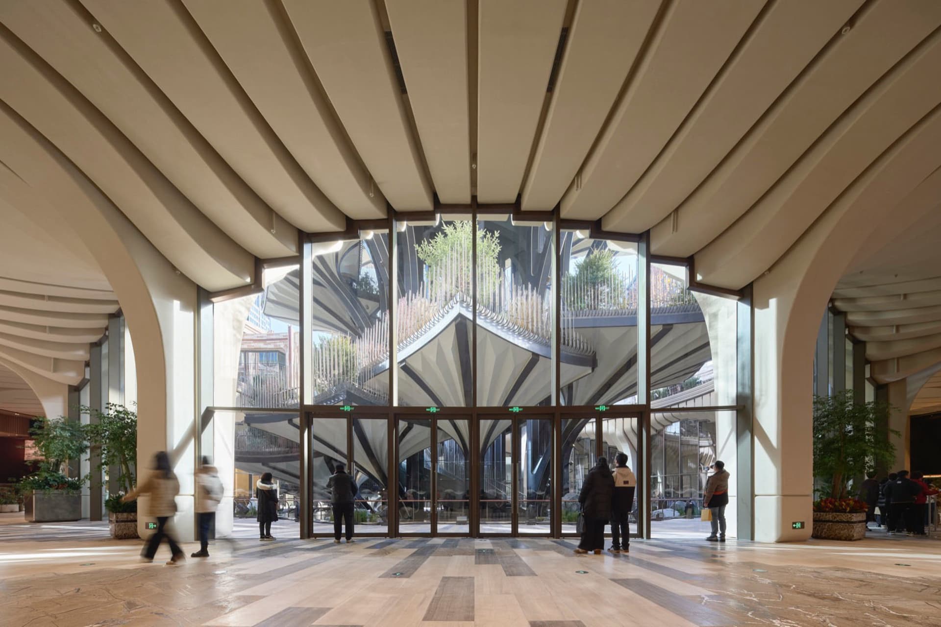 Modern lobby with glass walls and arched columns.