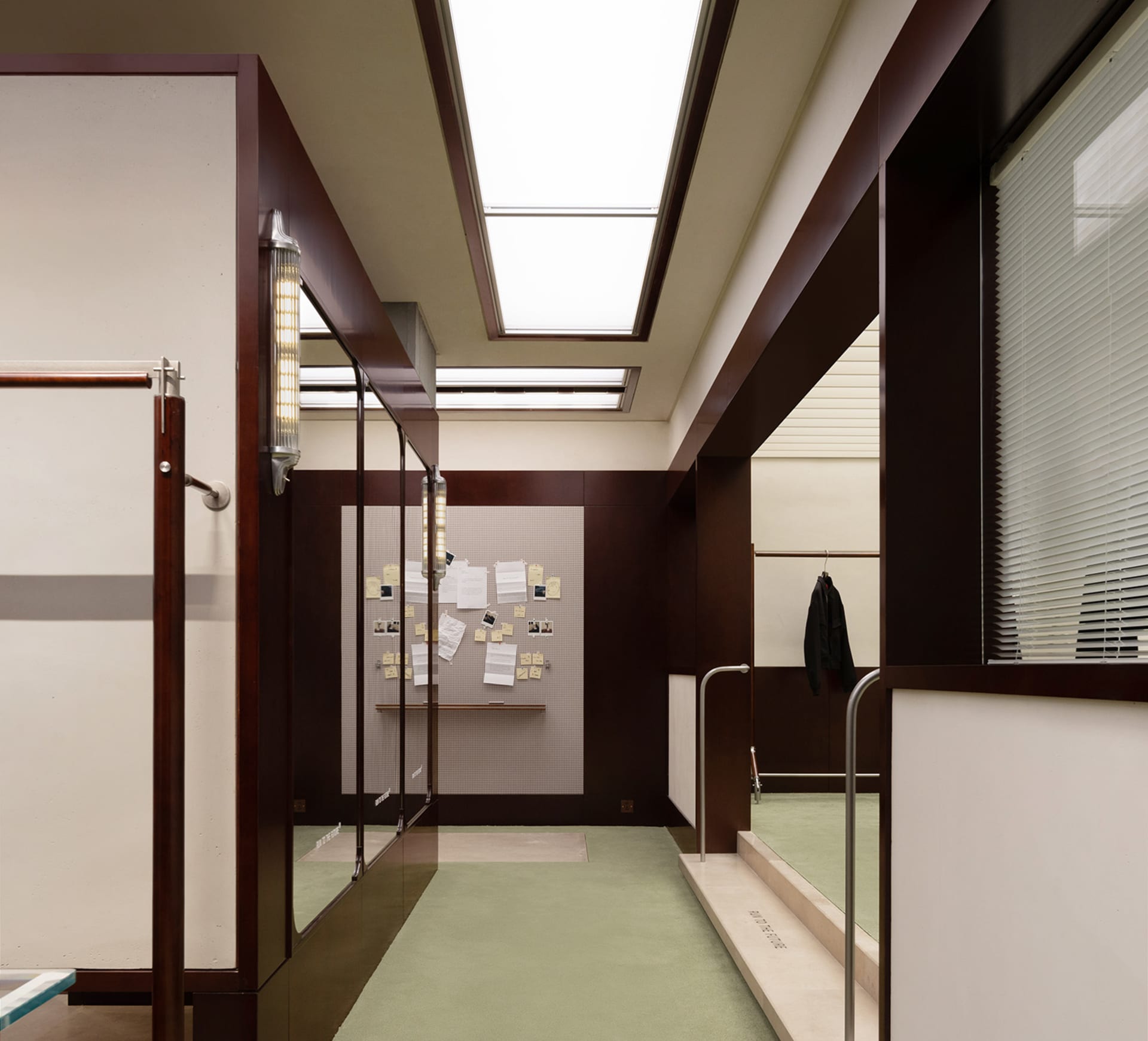 An office space featuring modern architectural elements such as glass doors, wood accents, and concrete flooring.