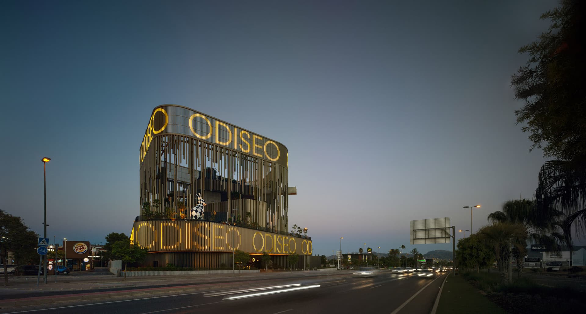 Modern building with illuminated signage and lights at dusk