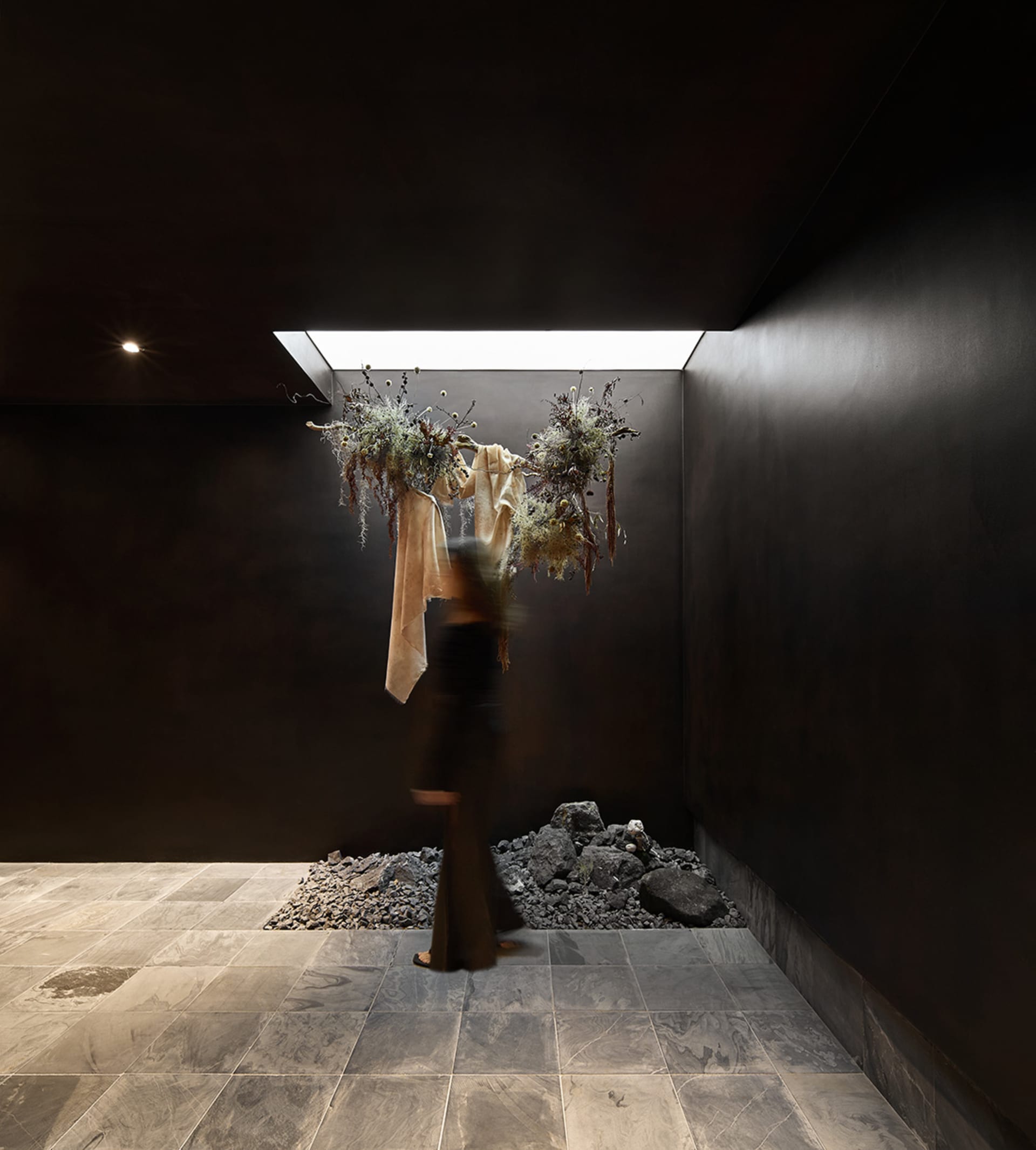 A minimalist space with concrete walls and a skylight.
