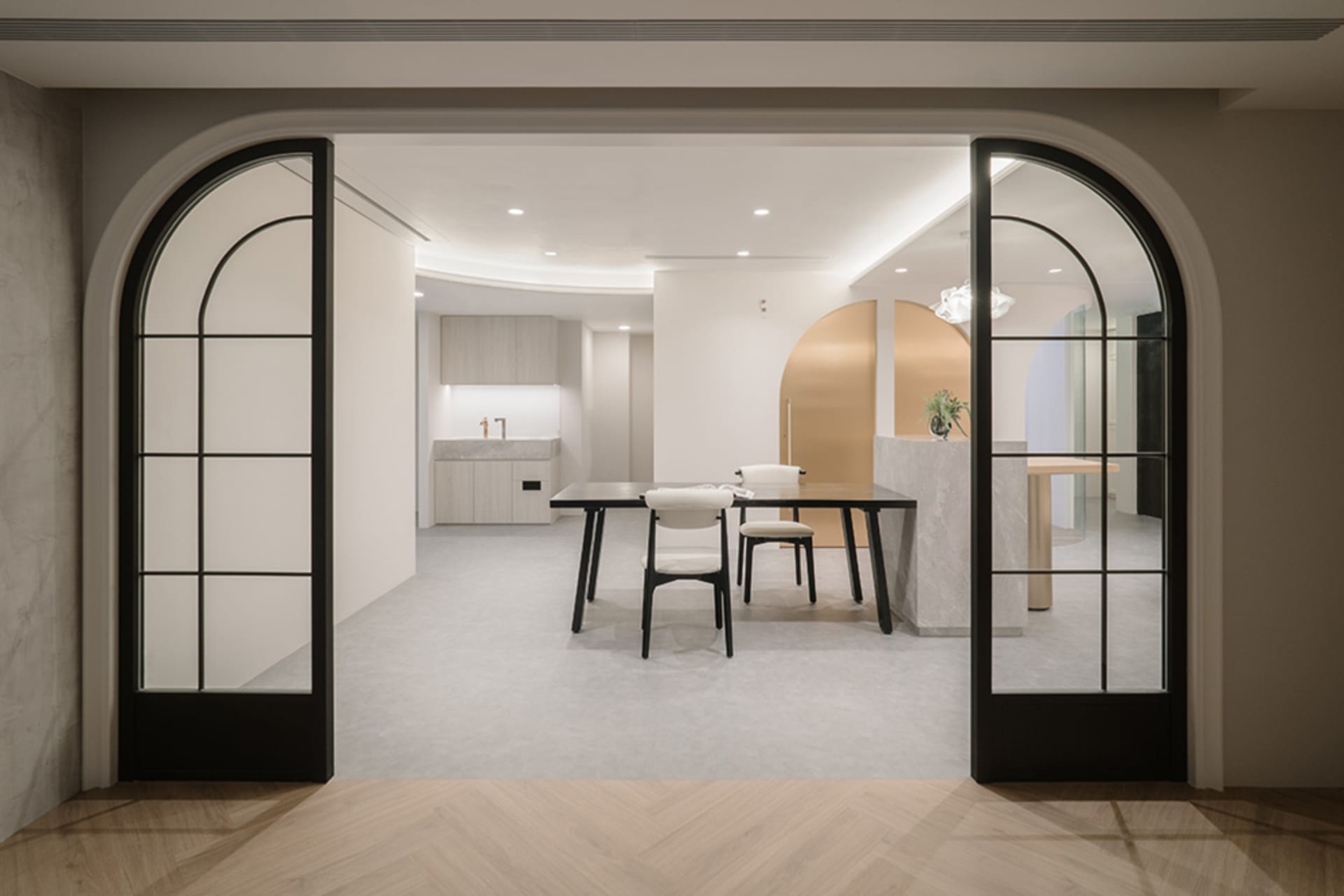 A minimalist modern home office with a concrete floor and white walls.
