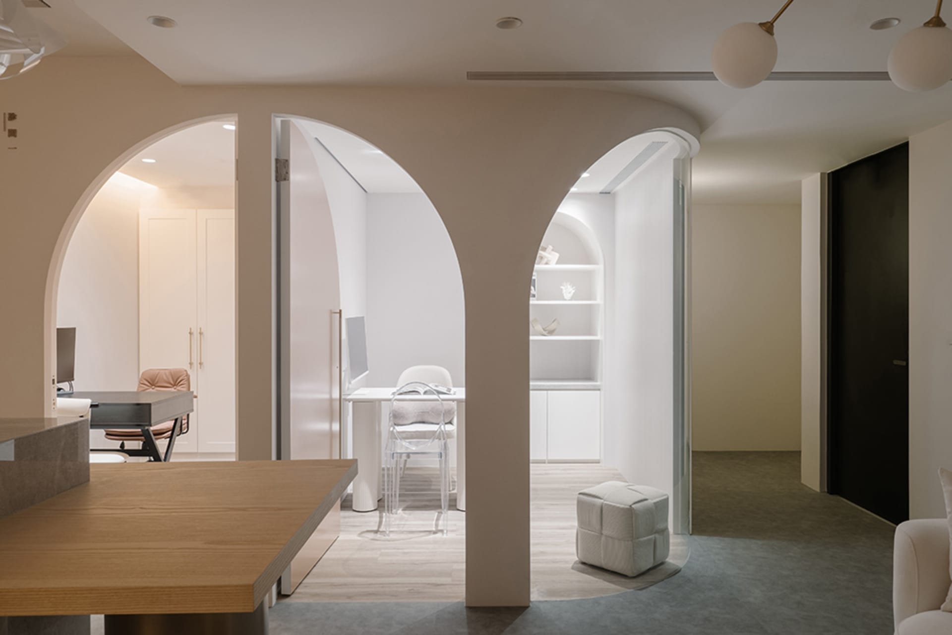 A modern office space with concrete, glass, and white furniture.