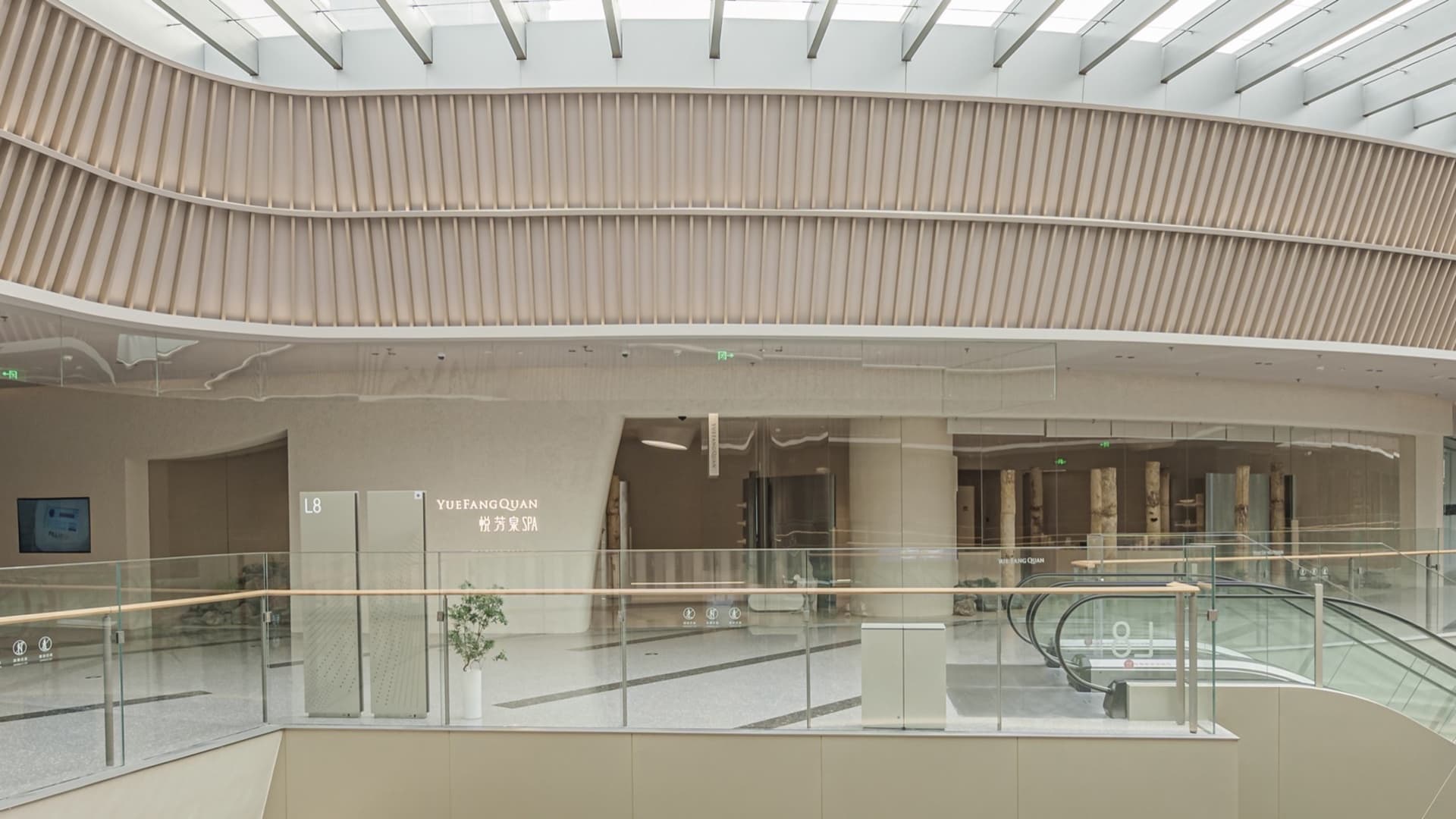 現代購物中心擴建區的室內視角,展現玻璃、混凝土與木質建築元素。