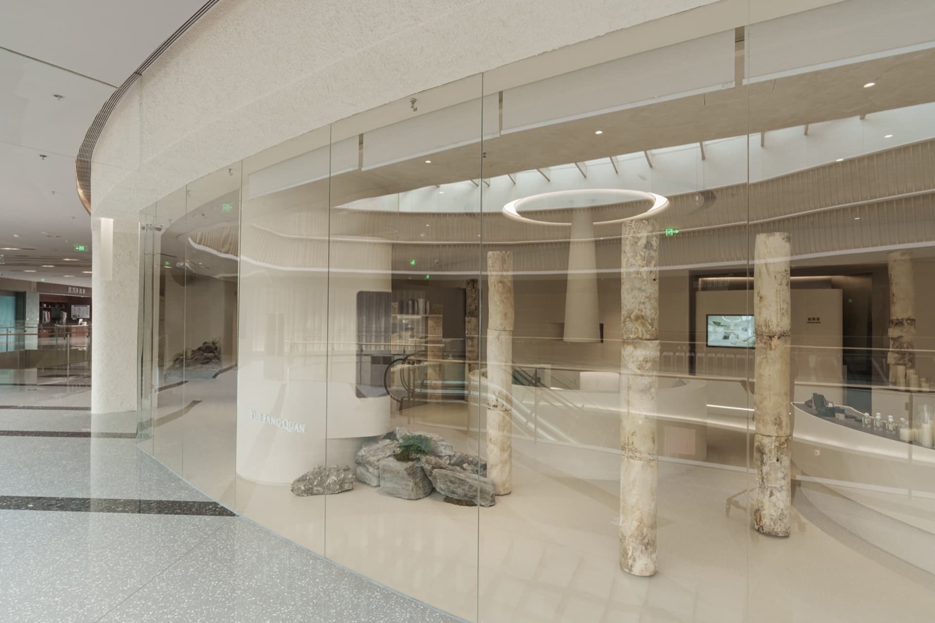 Modern shopping center featuring glass, concrete, and stone materials.
