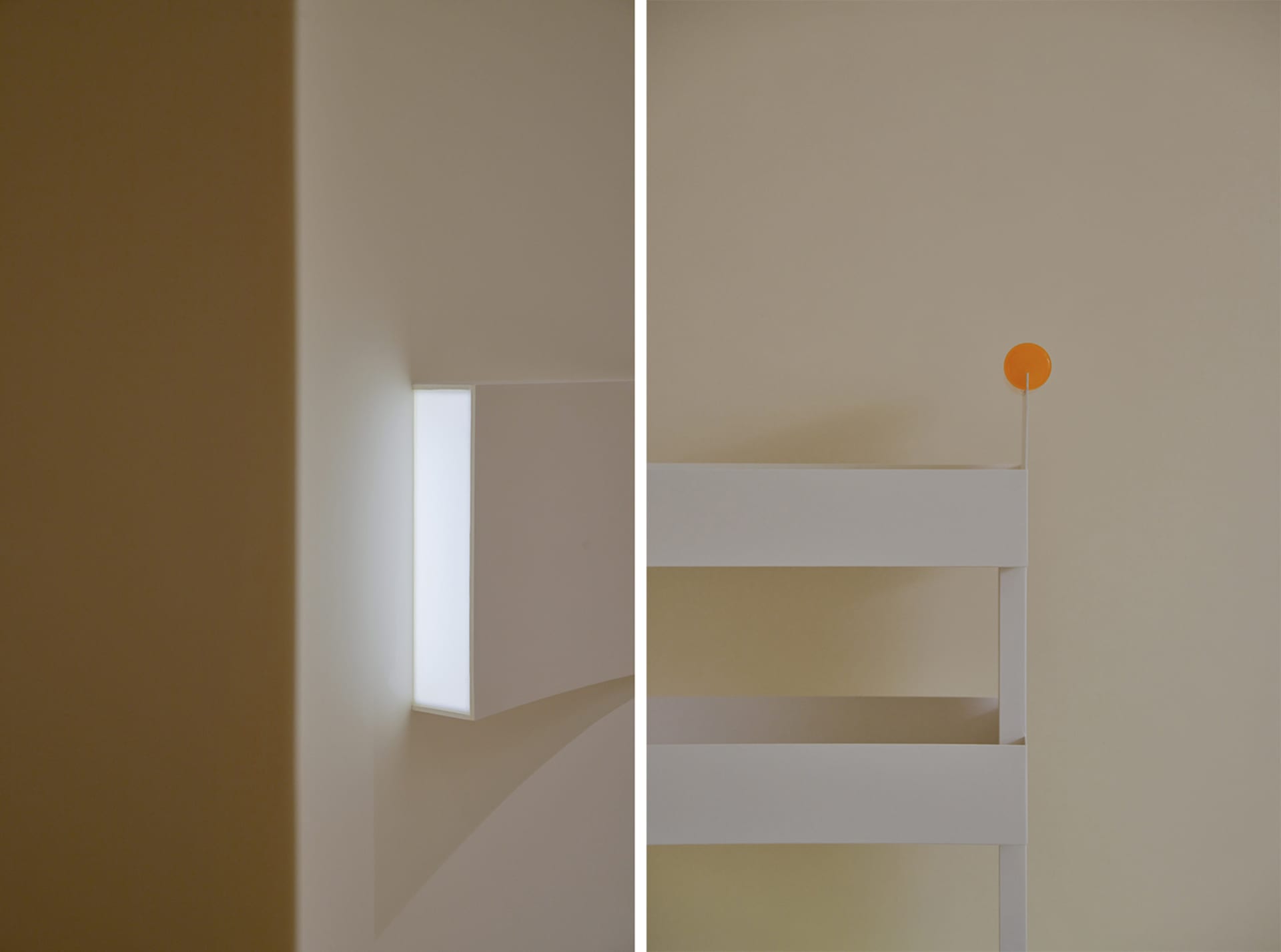 An interior design featuring a blank wall with a modern light fixture and a white bunk bed with an orange circular object.