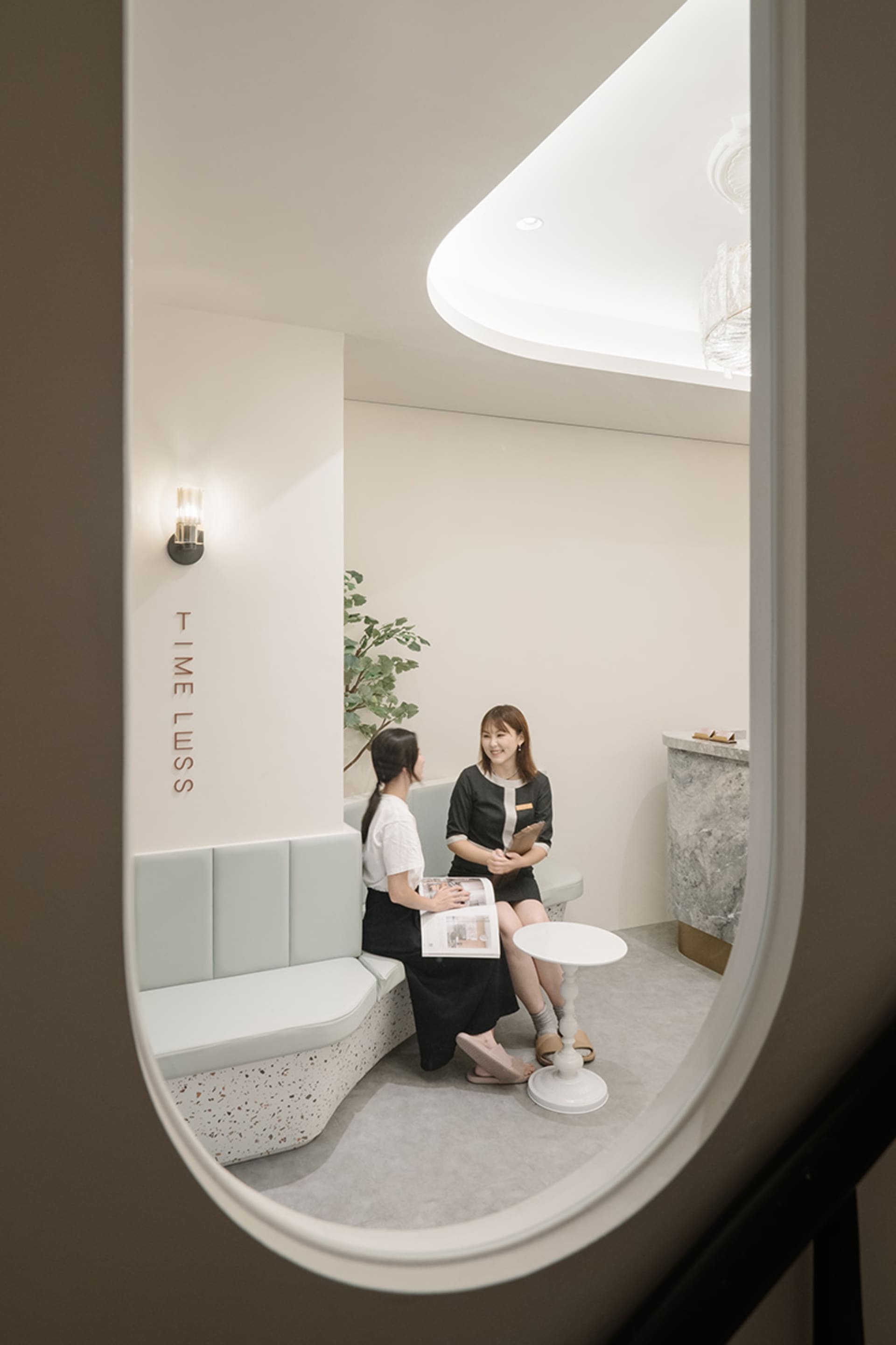 兩位女性在現代水療接待區，擁有俐落簡約的室內設計。