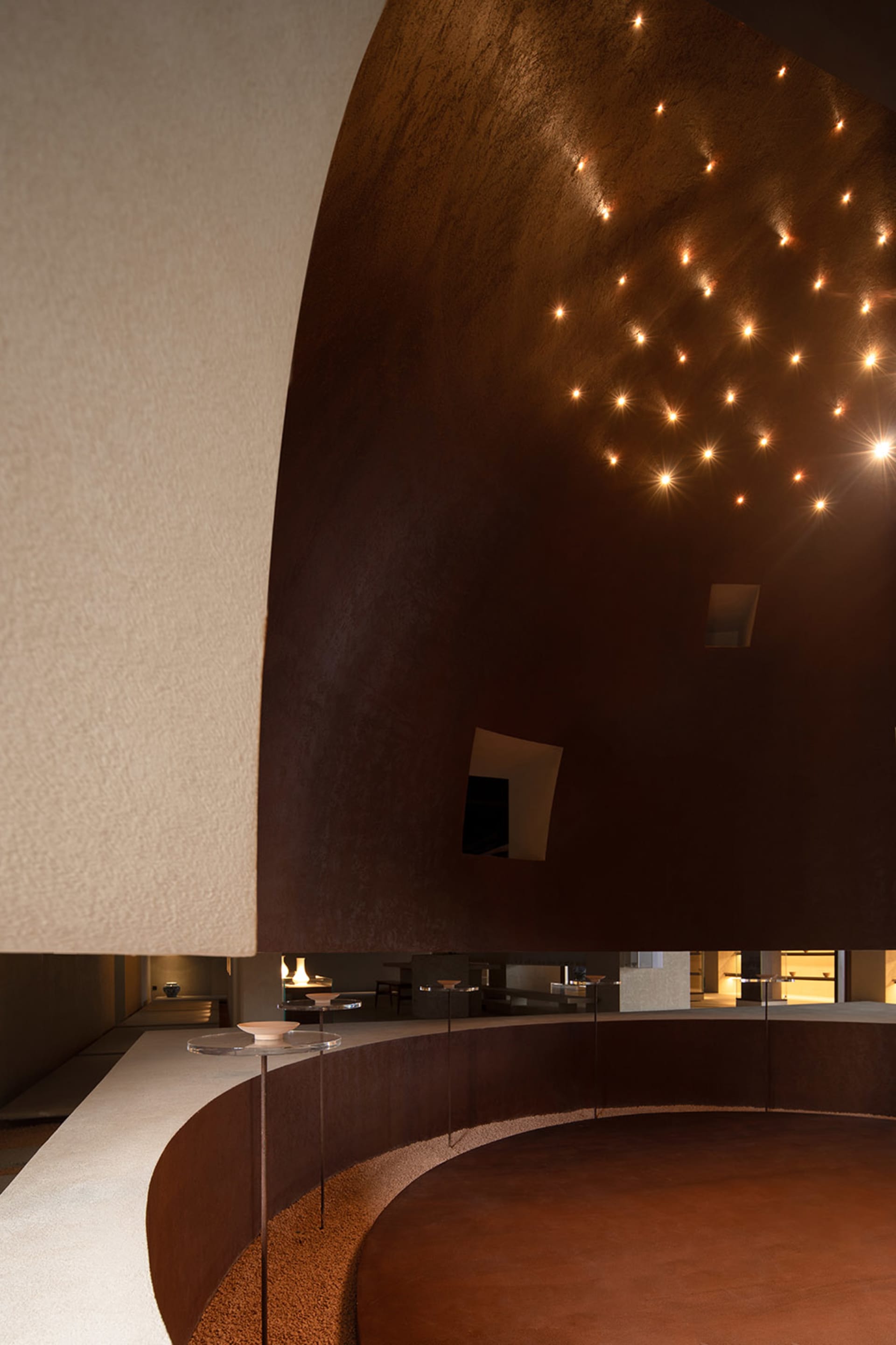 An interior space with a minimalist design featuring clay and metal materials.