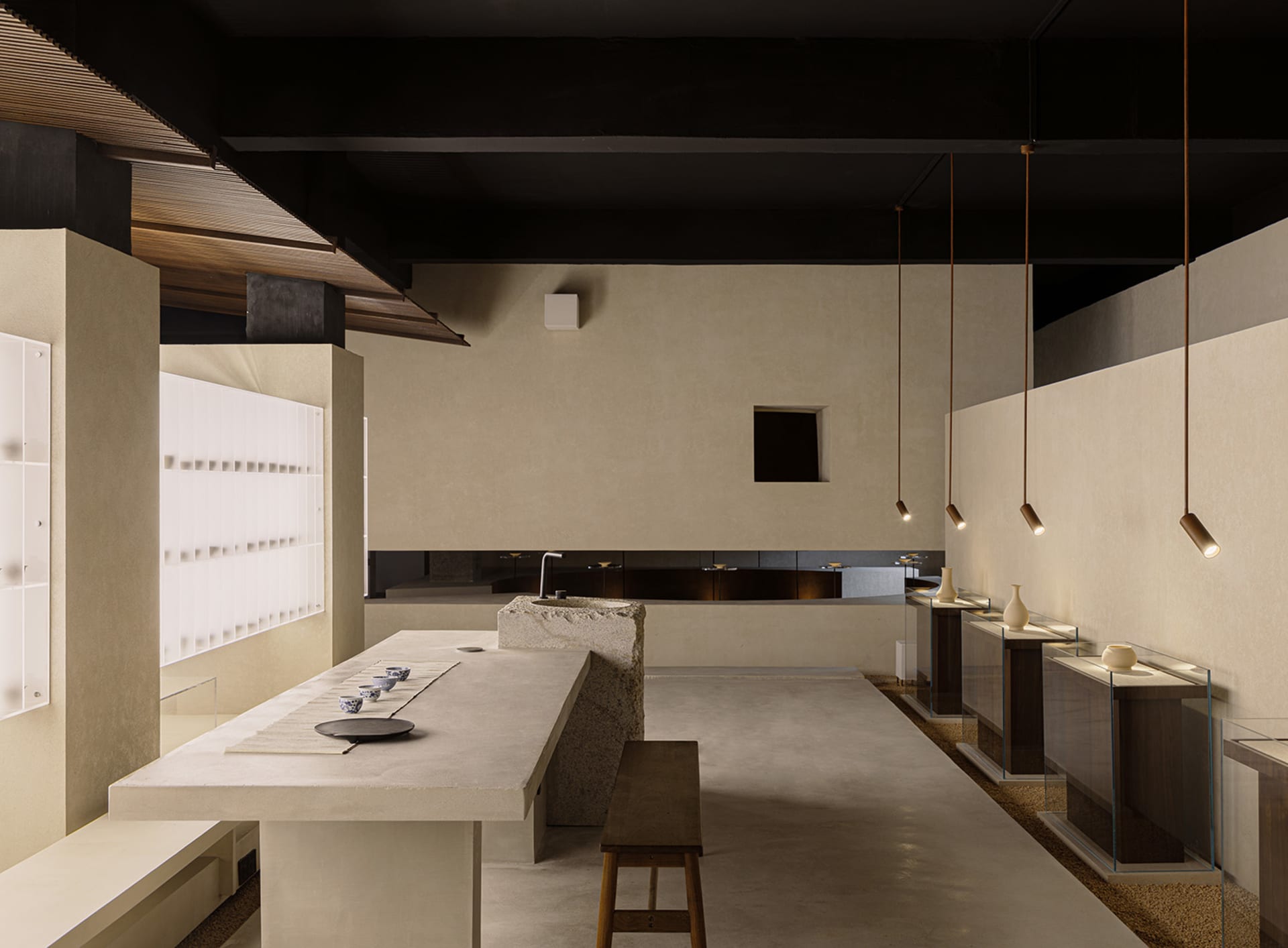 Minimalist restaurant interior with concrete countertops and wooden stools