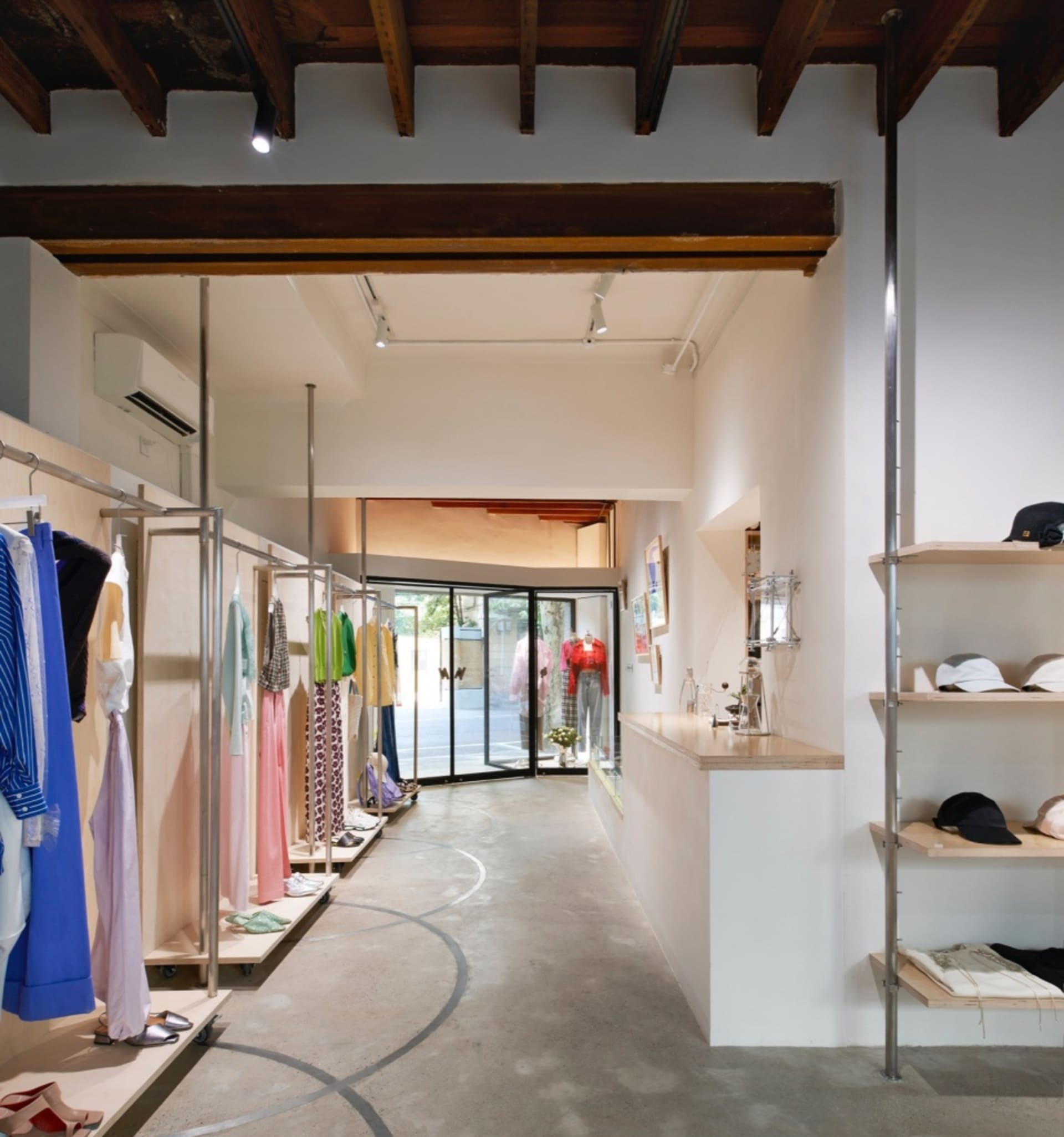 服裝零售店內有混凝土牆面、玻璃展示櫃，以及木質裝飾元素。