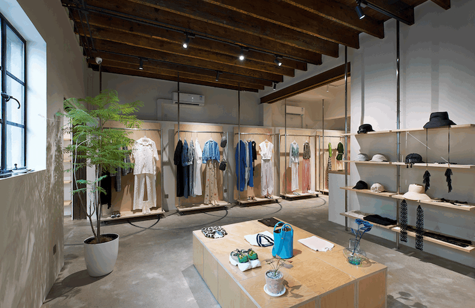 服裝店零售空間,展現木質元素與掛在衣架上的服飾