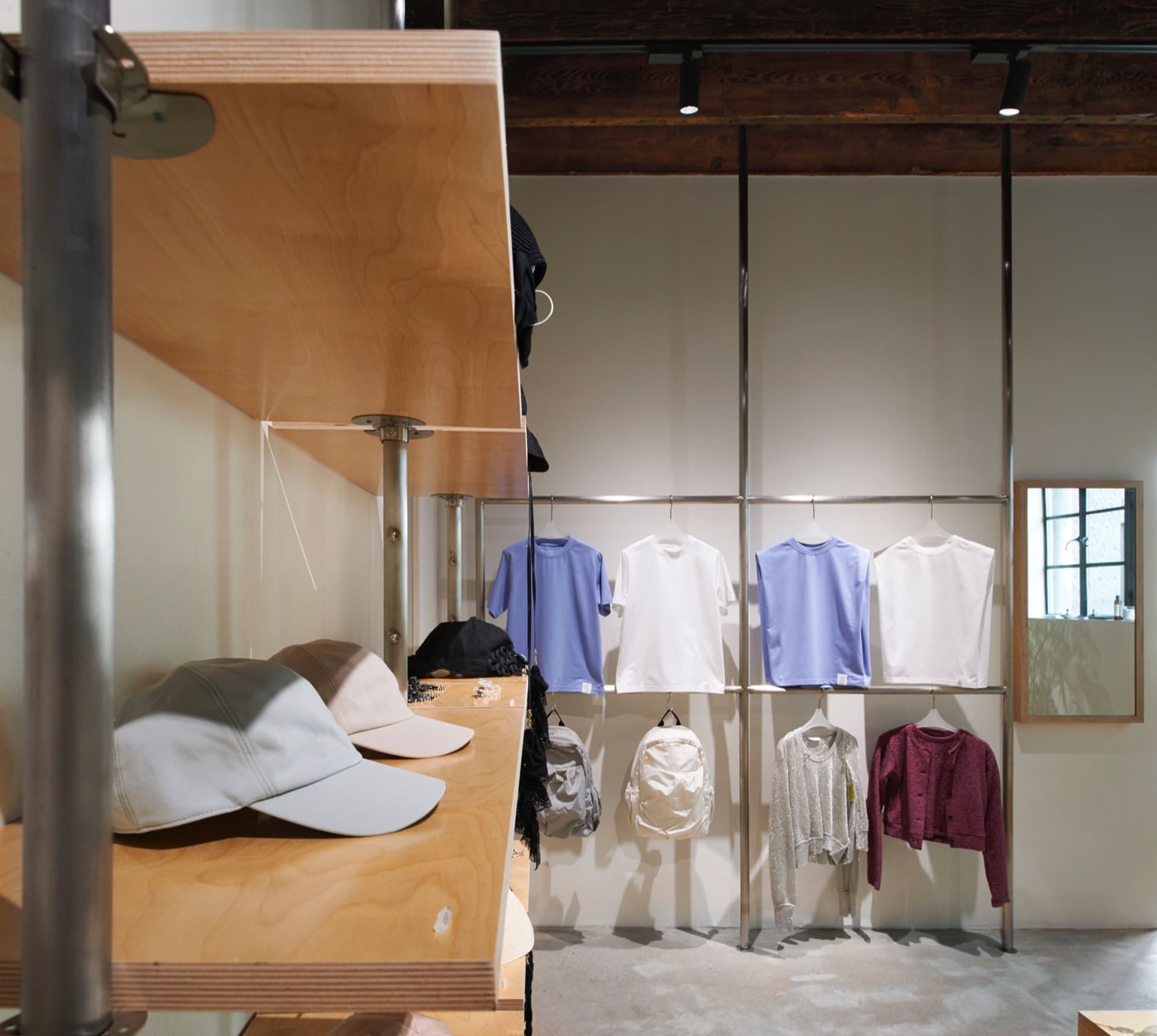 現代零售店內的金屬貨架展示各式服裝與配件。