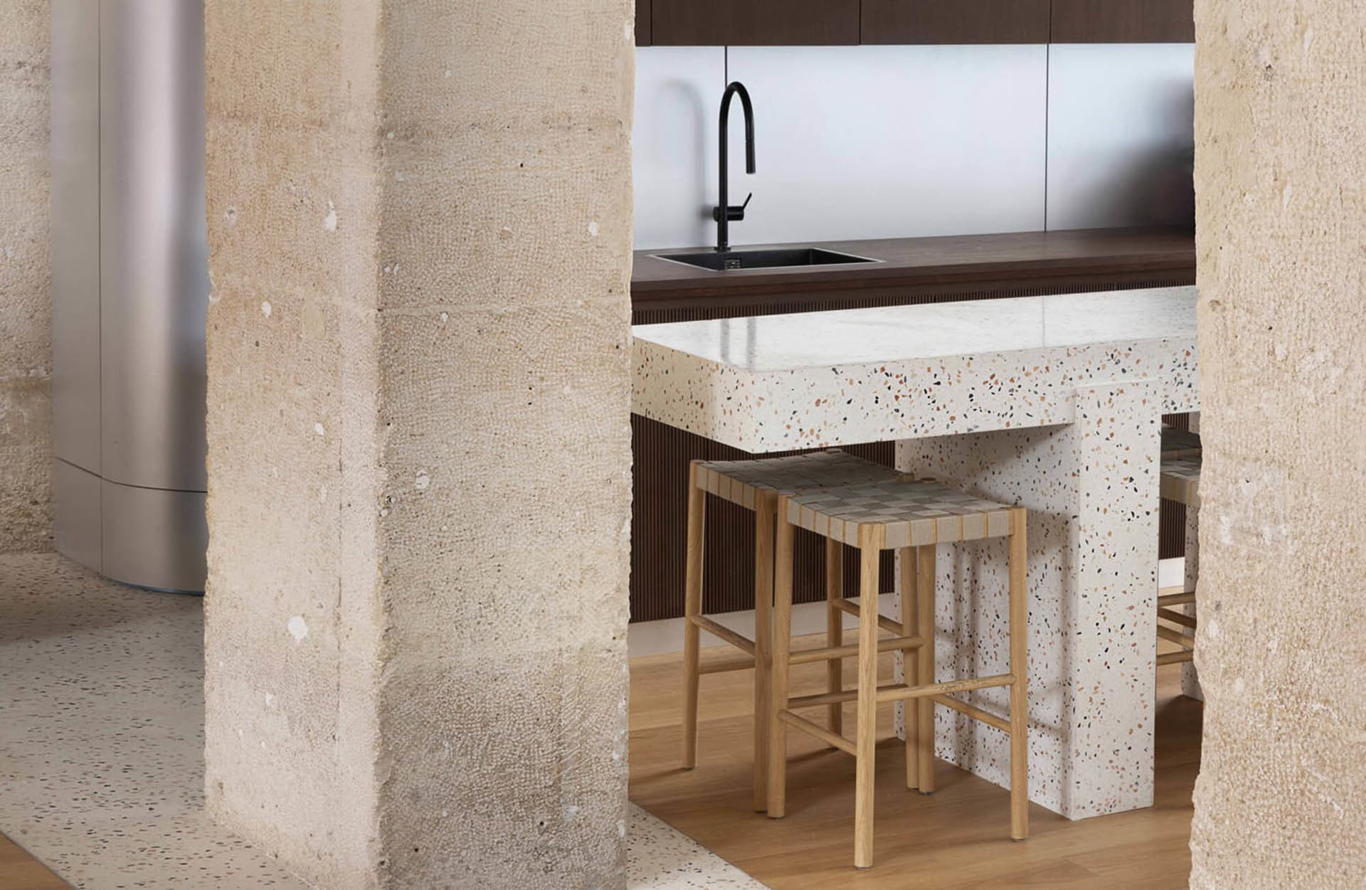 Modern kitchen with terrazzo countertop and minimalist design.