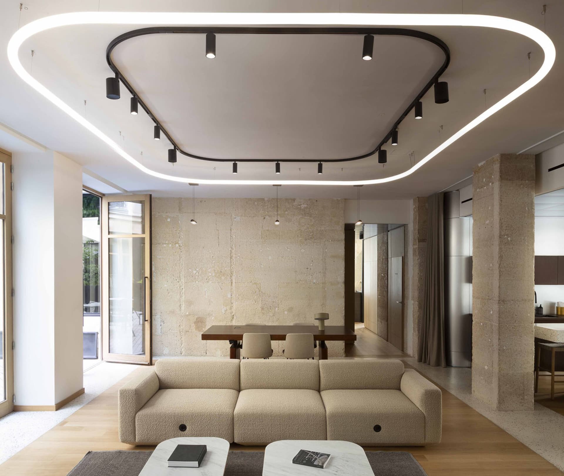 A modern living room featuring a beige cheesecloth sofa, minimalist design, and sleek lighting