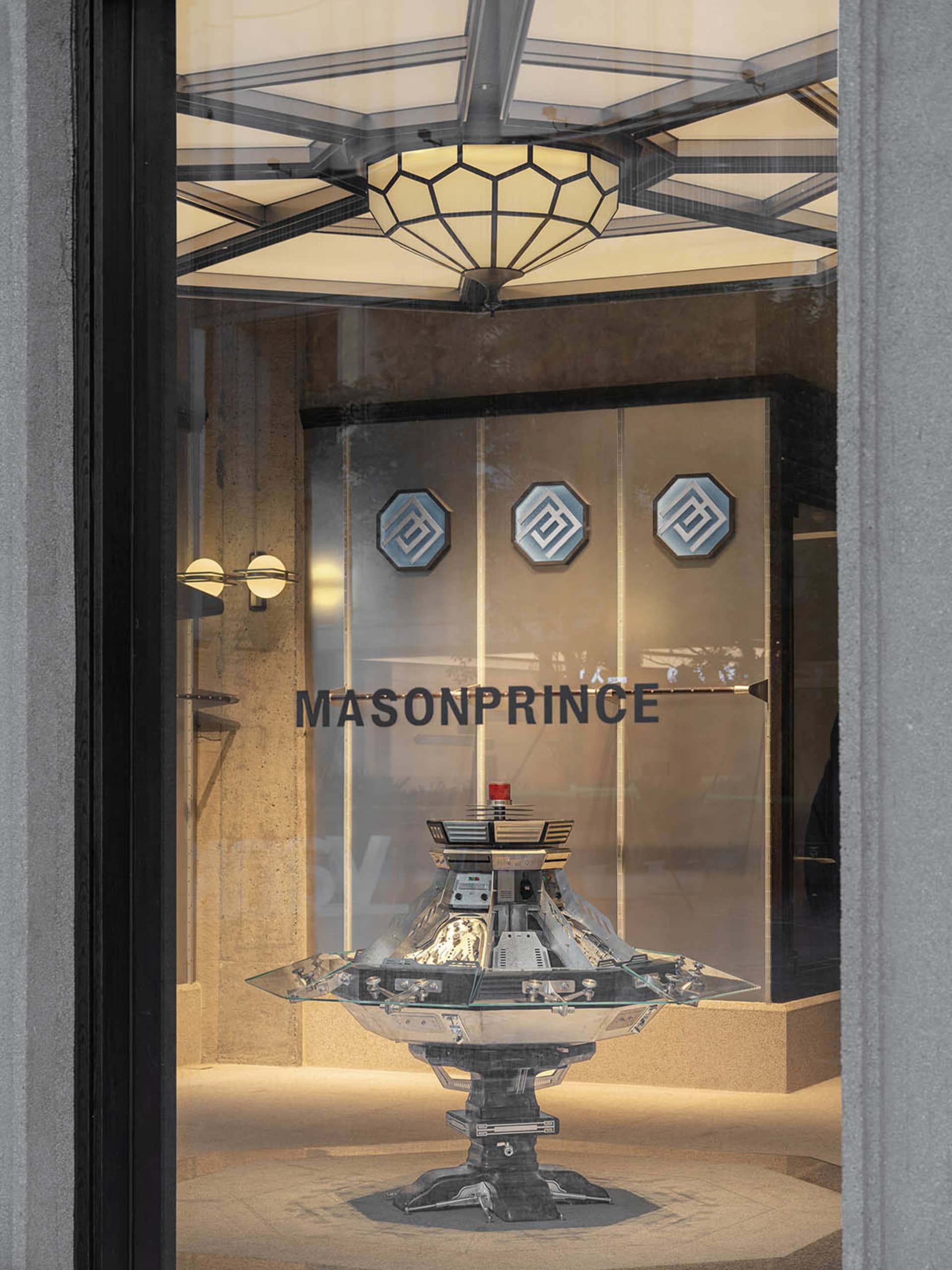 A futuristic metallic glass case display in a modern retail storefront.
