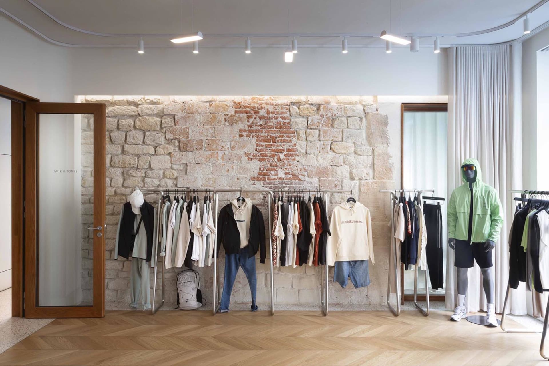 服裝店內有磚牆、木地板與懸掛式衣架