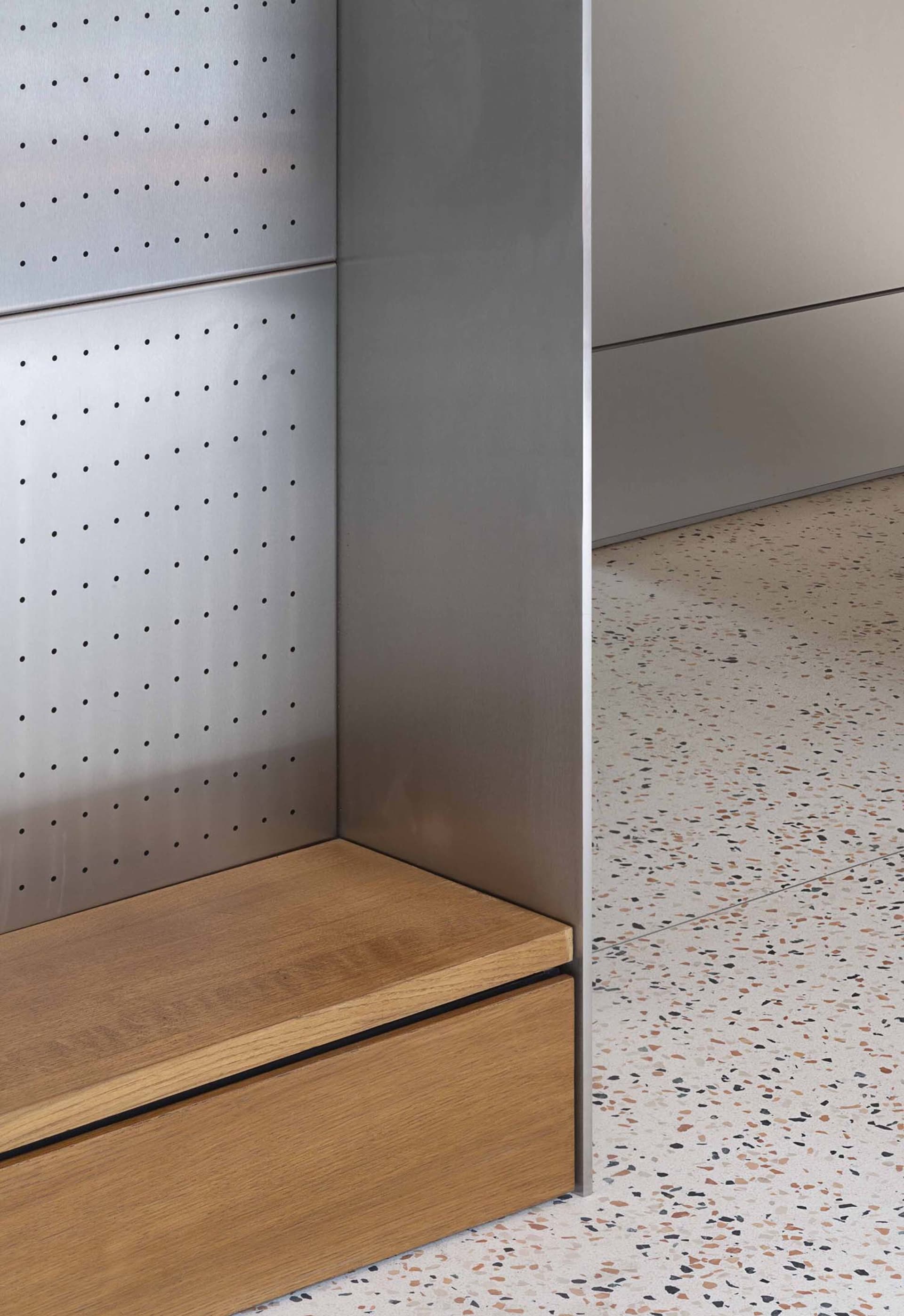 An industrial interior featuring metal walls, wooden accents, and terrazzo flooring.