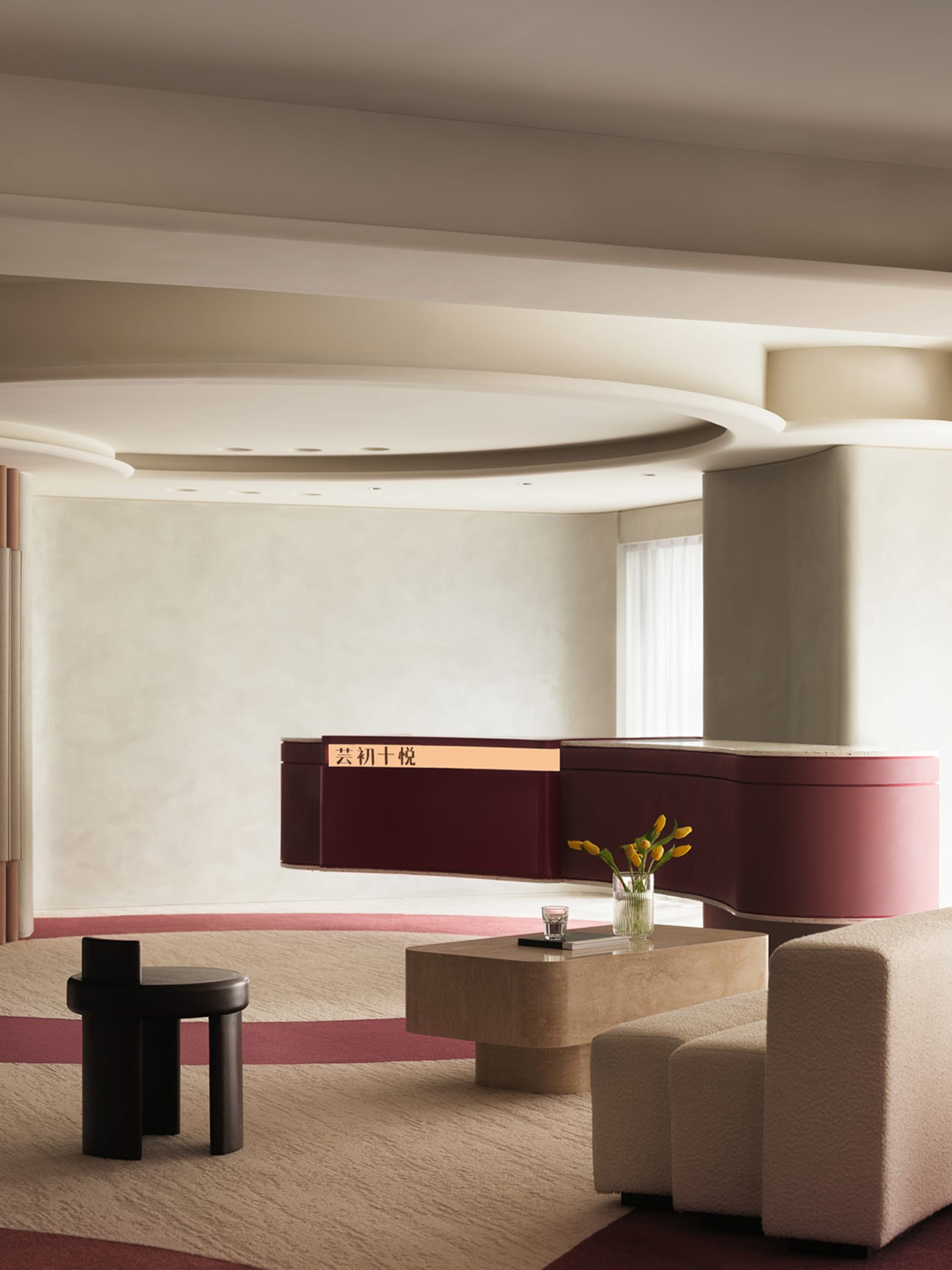 A modern lobby featuring concrete material with a circular ceiling light fixture and white walls.