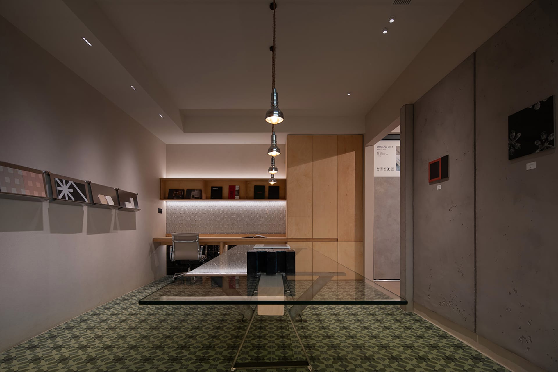 A minimalist office space featuring a glass table and modern design elements.