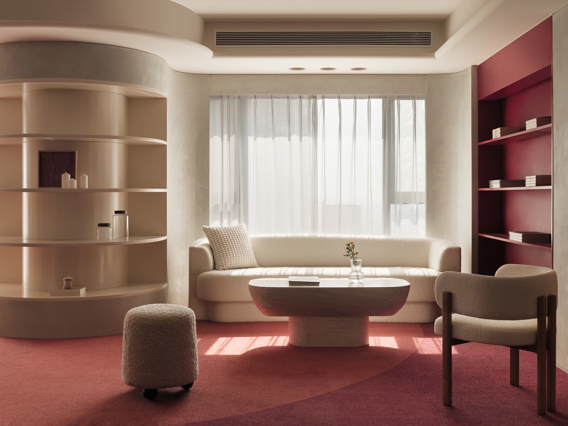 A modern living room with a white sofa, a red carpet, and a wooden coffee table.