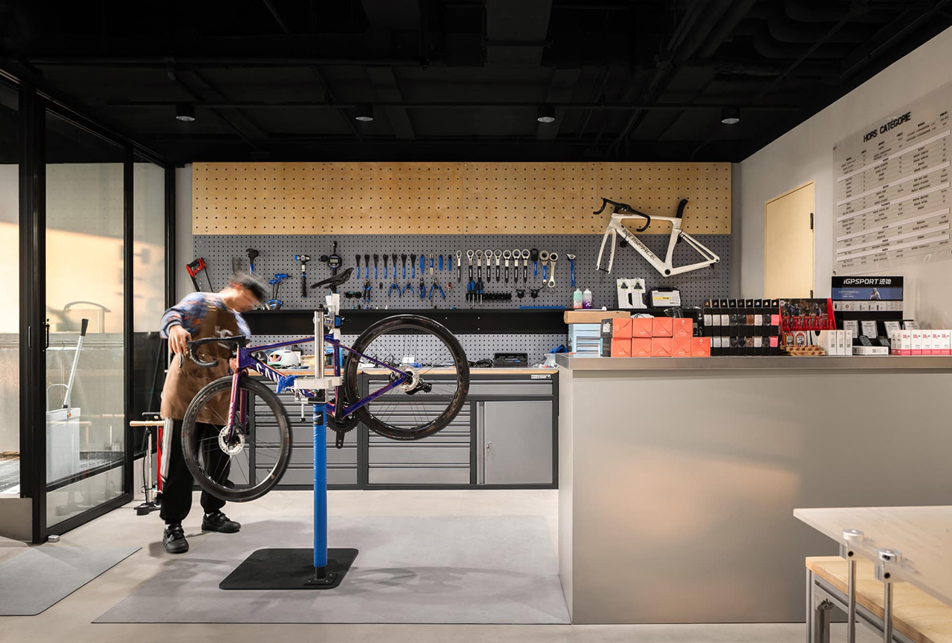 A man repairing a bicycle in an industrial-style bicycle repair shop.
